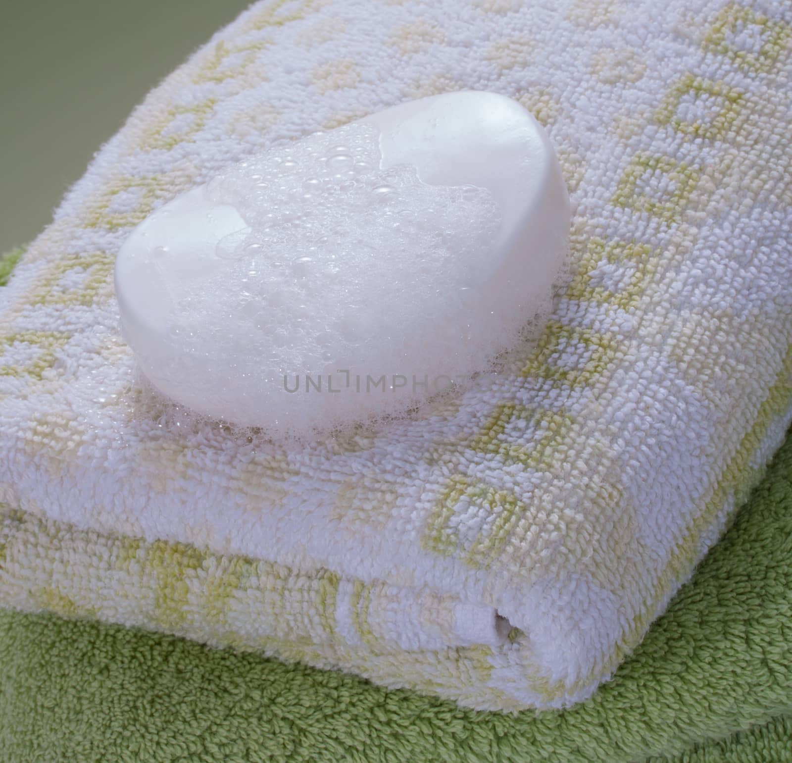 white wet foamy soap bar on bath towel