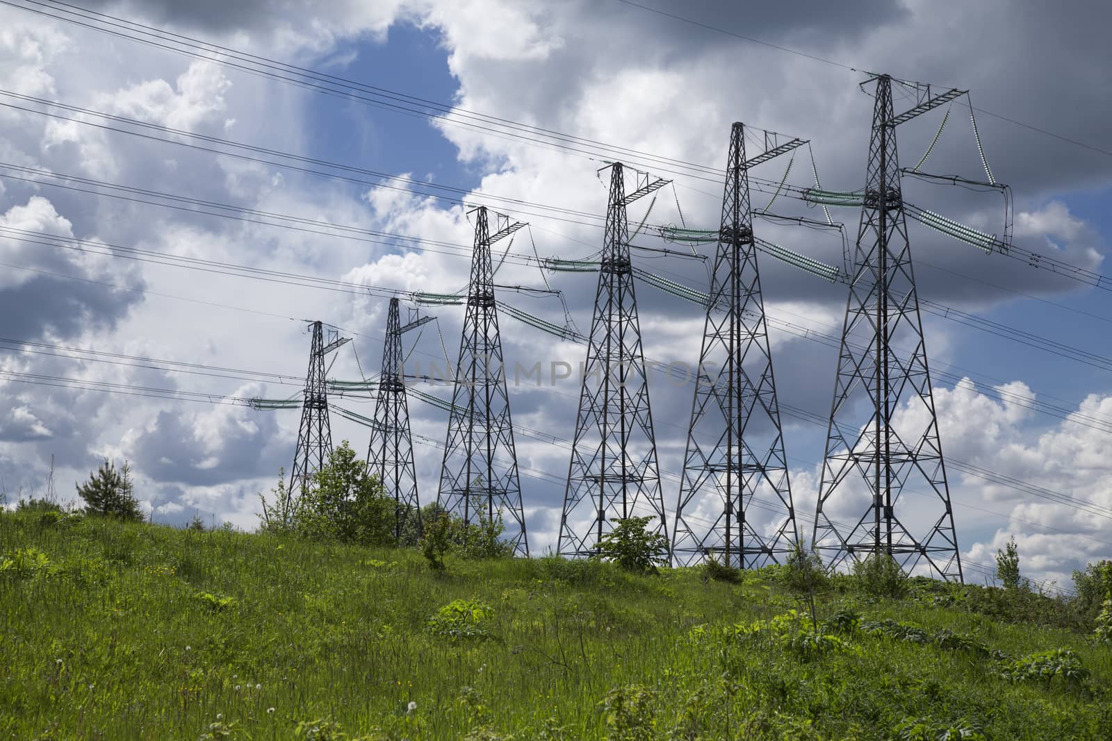 wide angle view of high voltage power pylons on against sky
