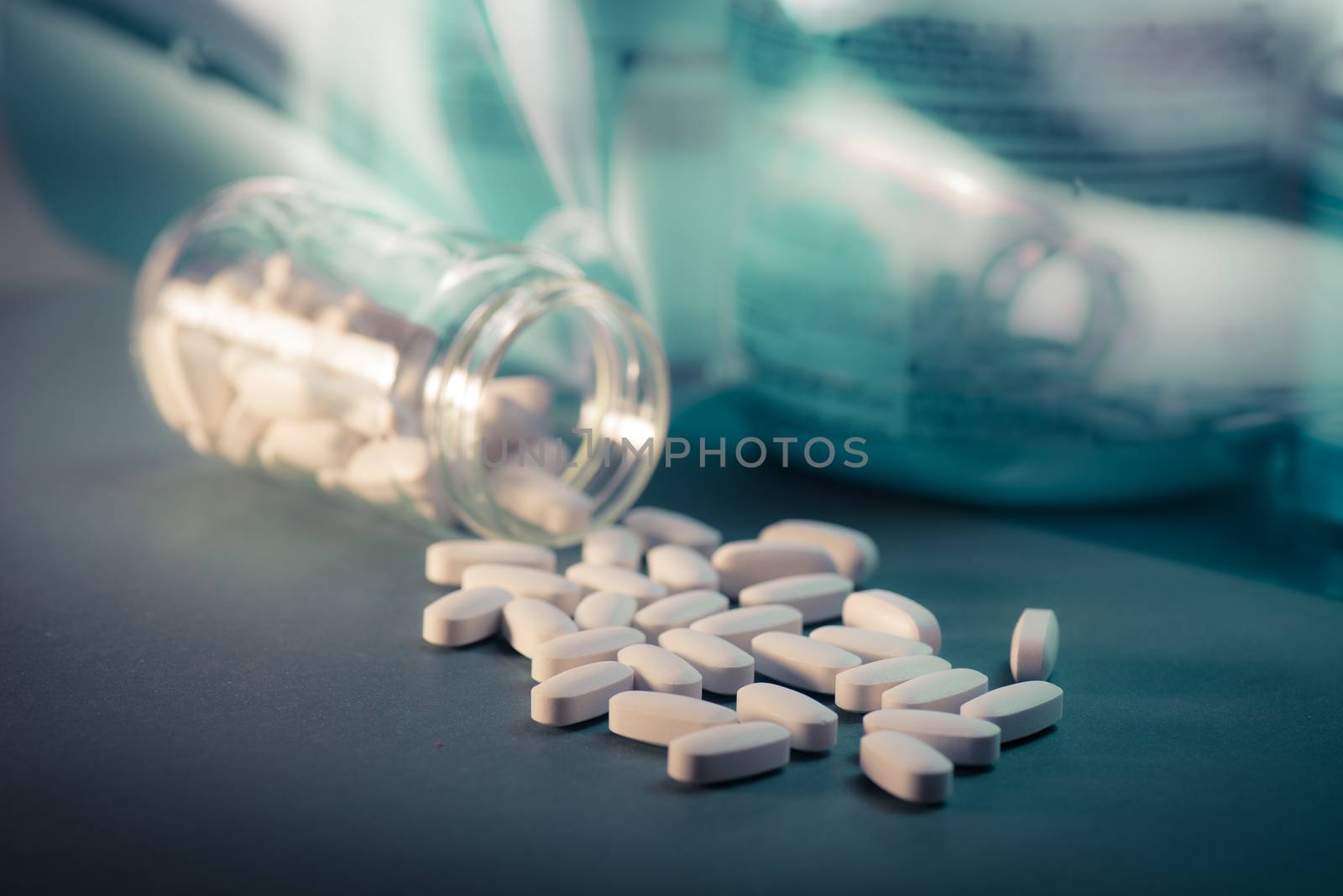 Drug, medicine or supplement pills on table with color effects. Health concept. Medical background.