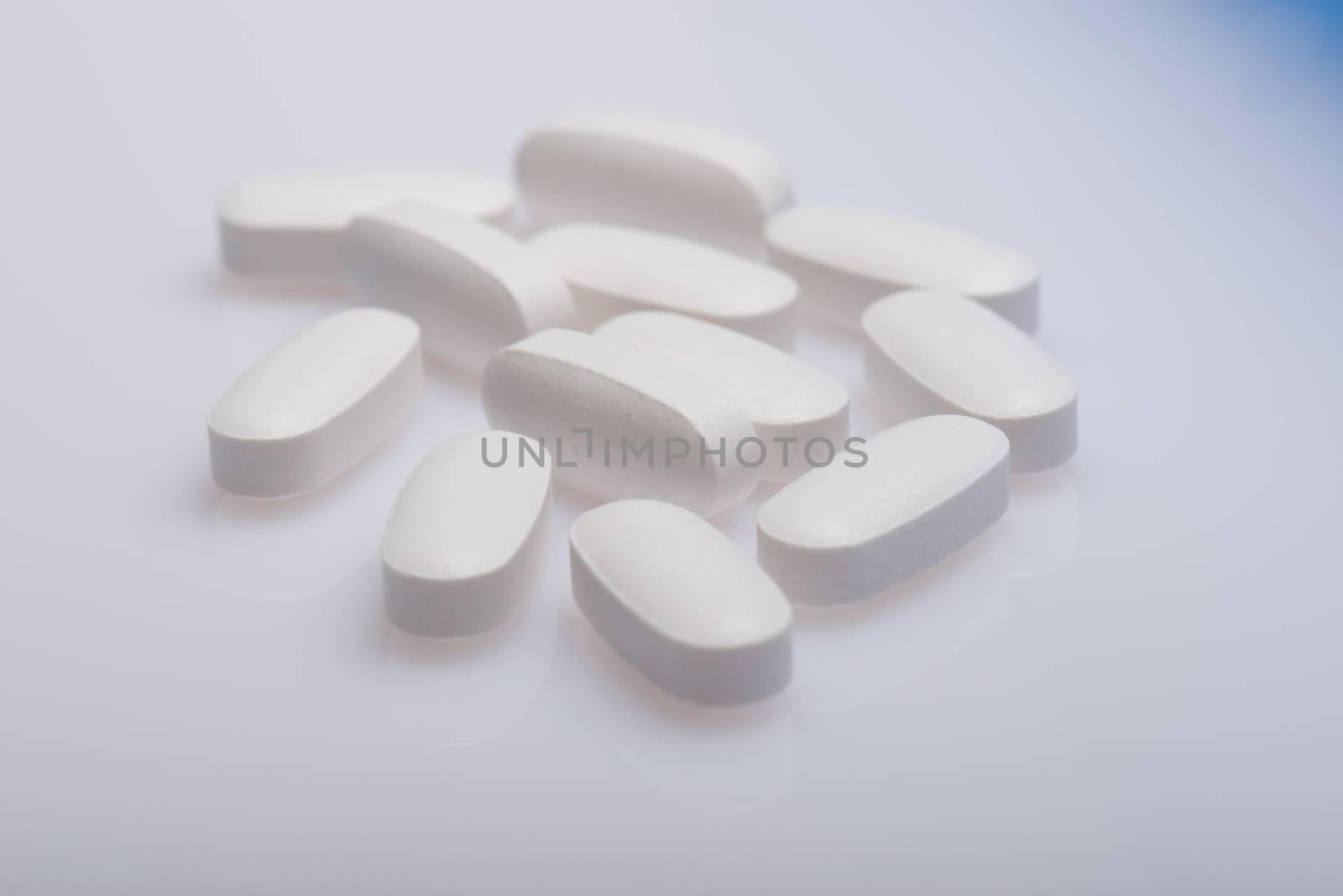 Drug, medicine or supplement pills on table with color effects. Health concept. Medical background.