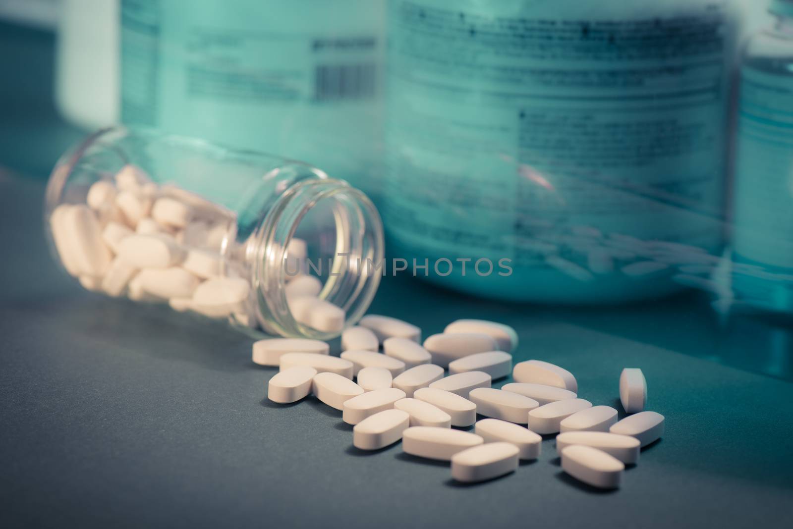 Drug, medicine or supplement pills on table with color effects. Health concept. Medical background.