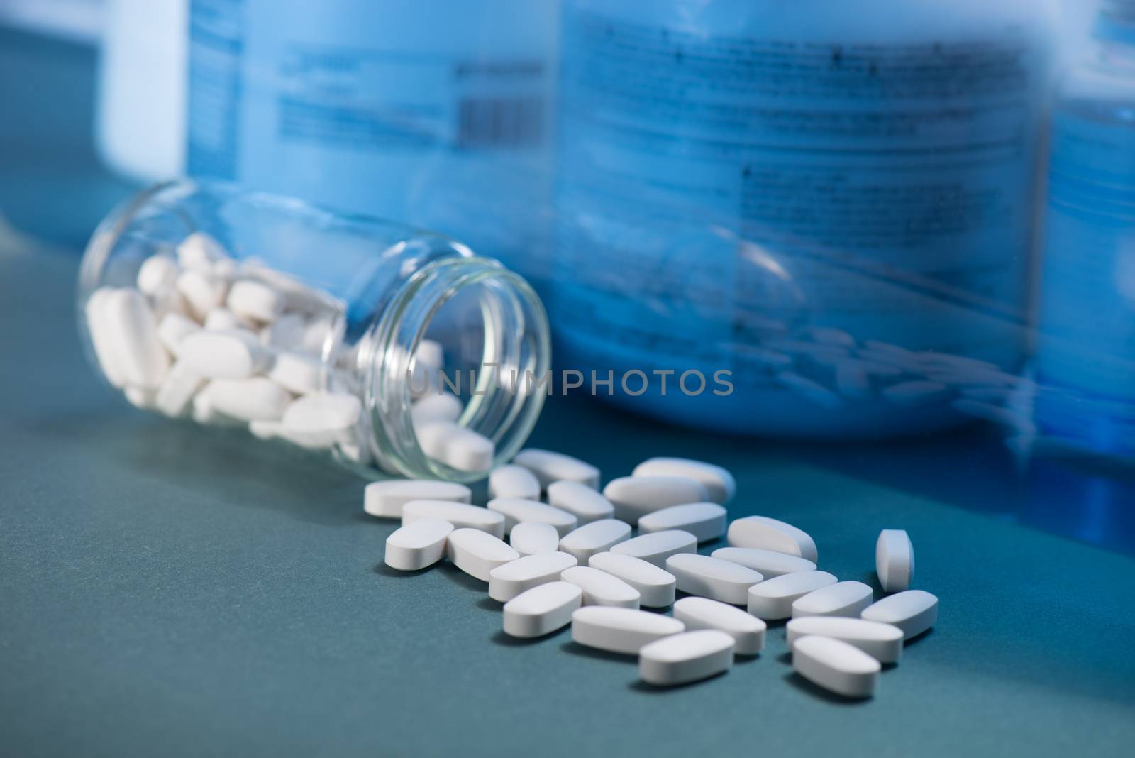 Drug, medicine or supplement pills on table with color effects. Health concept. Medical background.