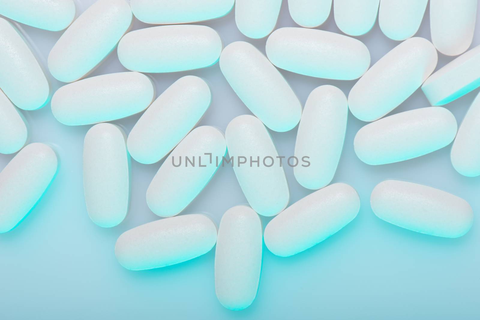 Drug, medicine or supplement pills on table with color effects. Health concept. Medical background.