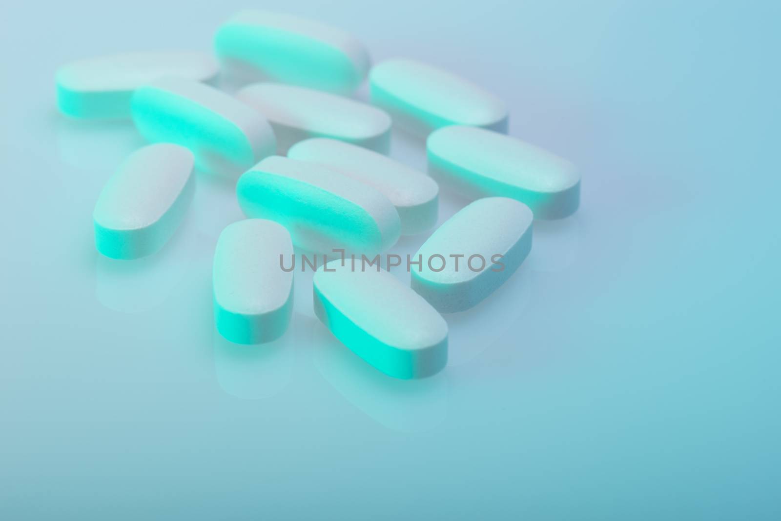 Drug, medicine or supplement pills on table with color effects. Health concept. Medical background.