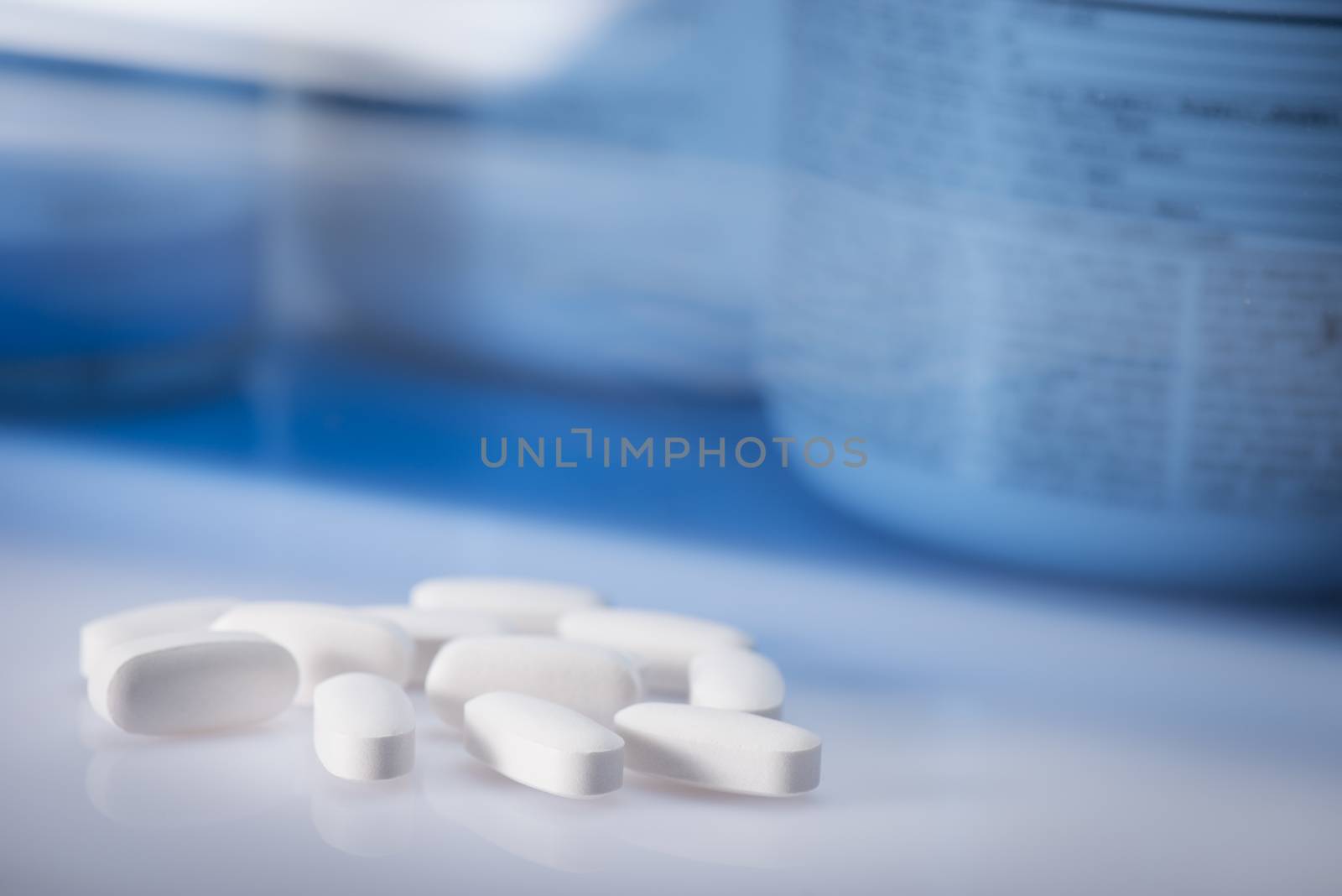 Drug, medicine or supplement pills on table with color effects. Health concept. Medical background.