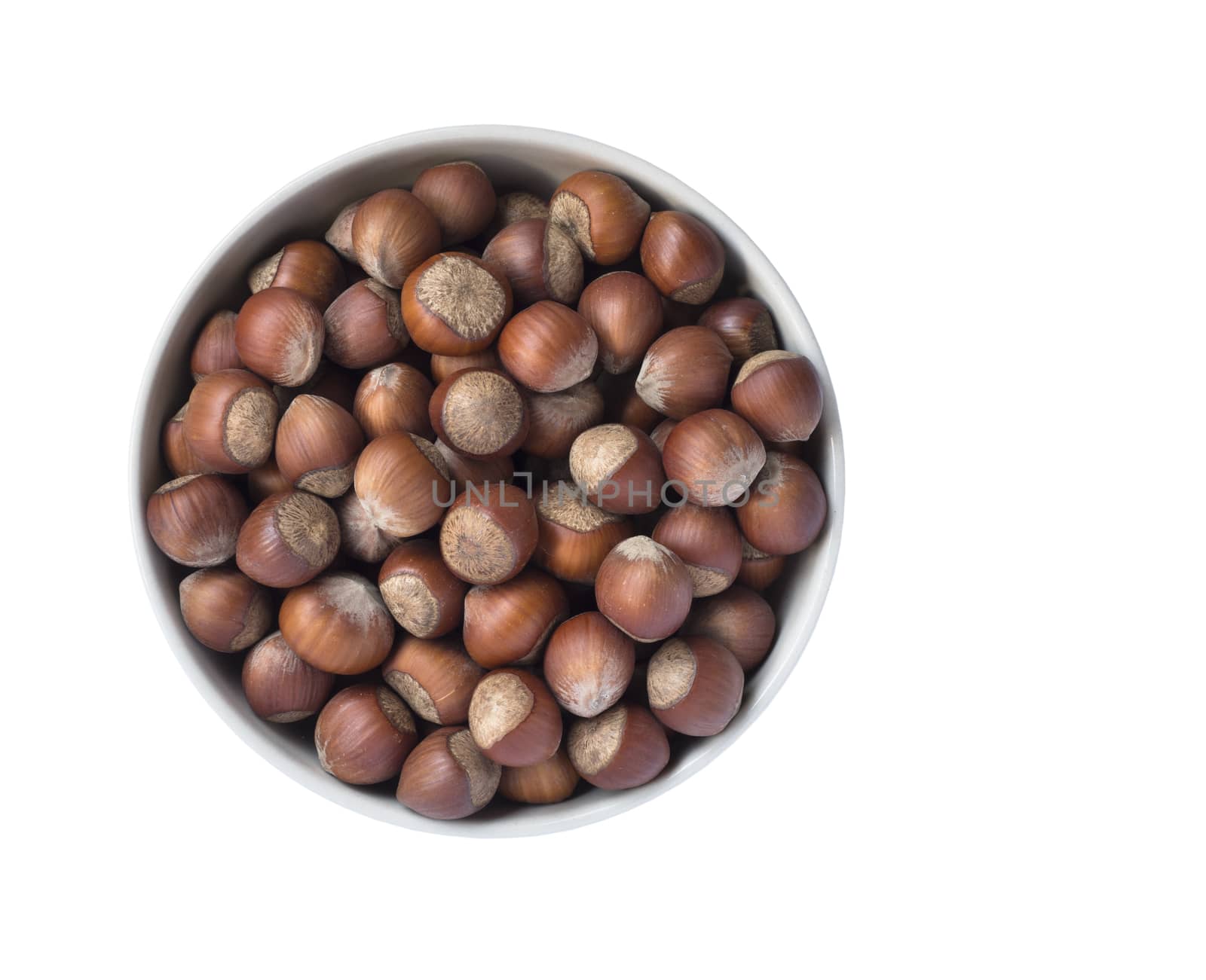 Full bowl of hazelnuts isolated on white background, top view.