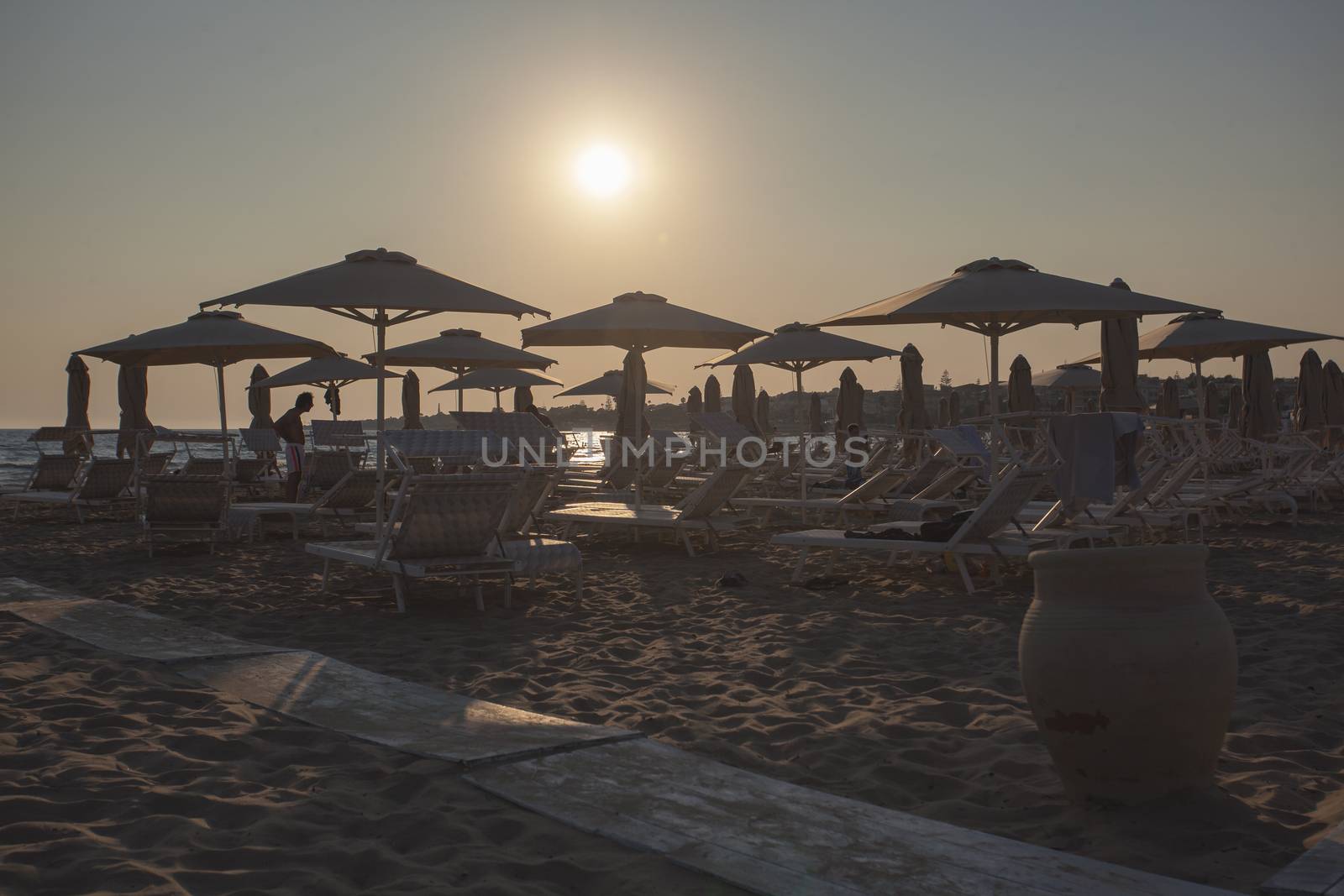 Sunbeds and umbrellas on Modica's beach at sunset