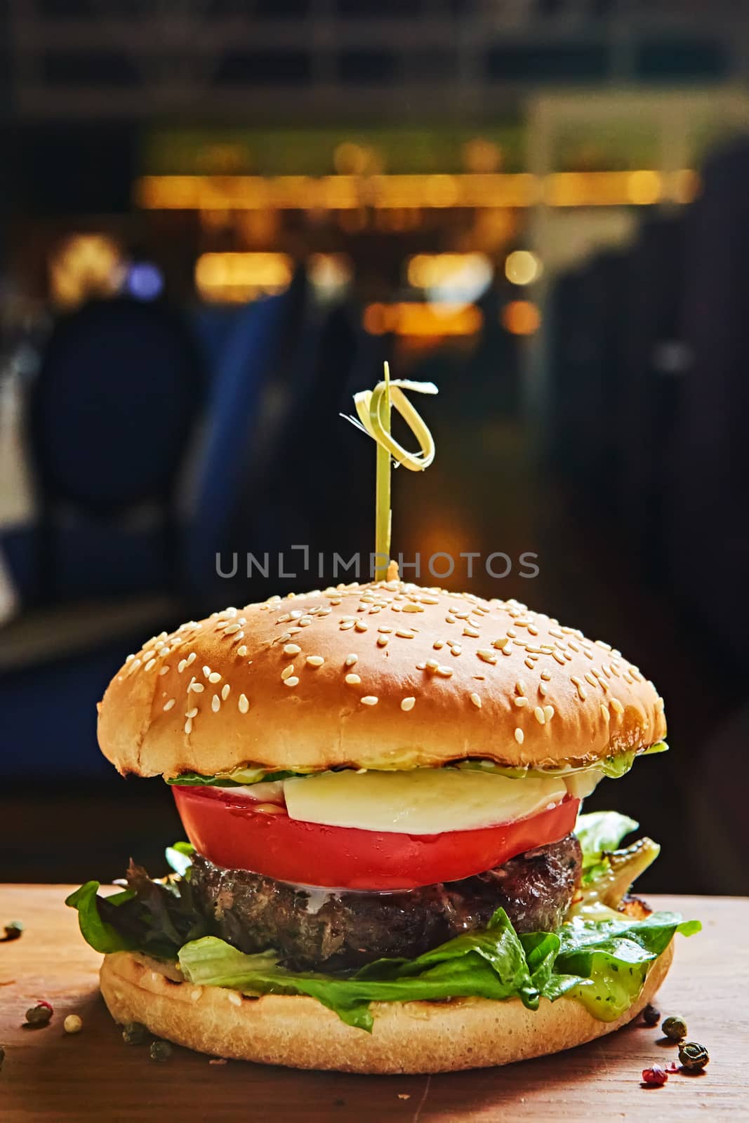 Beef burger with lettuce and mayonnaise served on a rustic wooden table of counter, with copy space