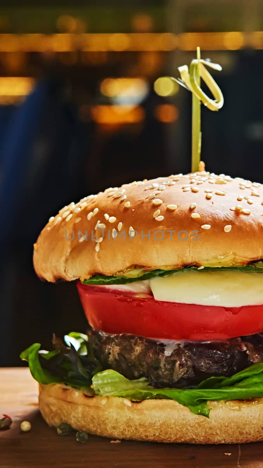 Beef burger with lettuce and mayonnaise served on a rustic wooden table of counter, with copy space