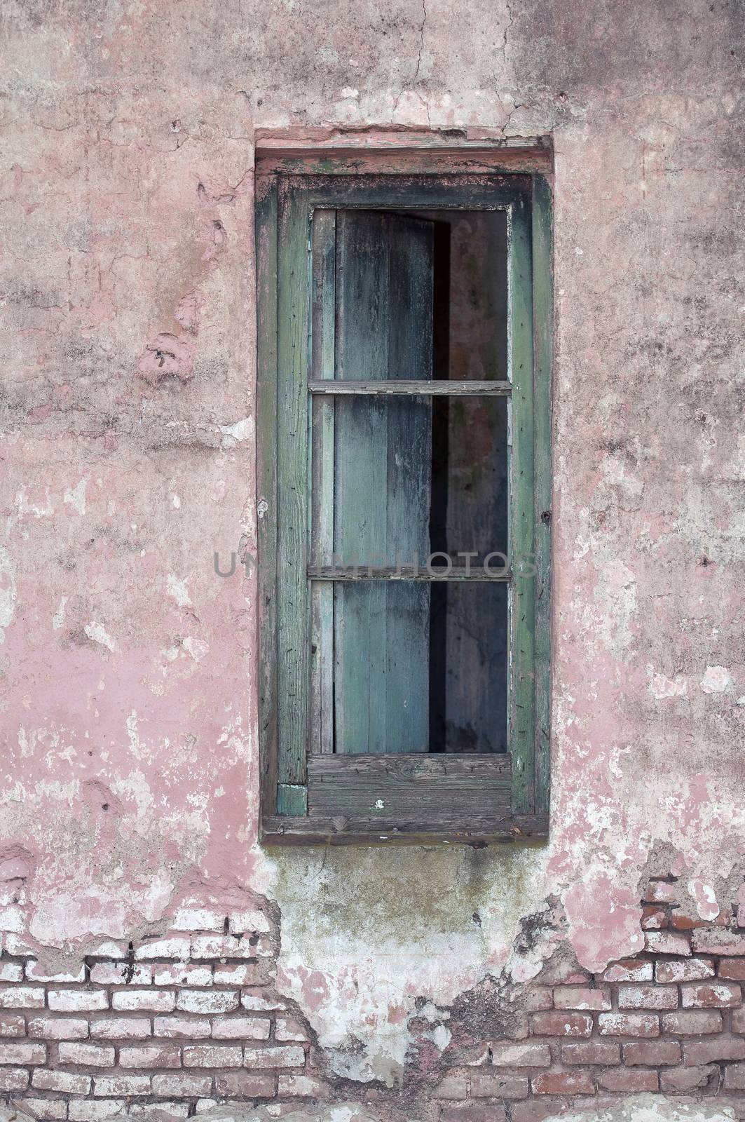 Stock image of an old window on exposed brick wall.
