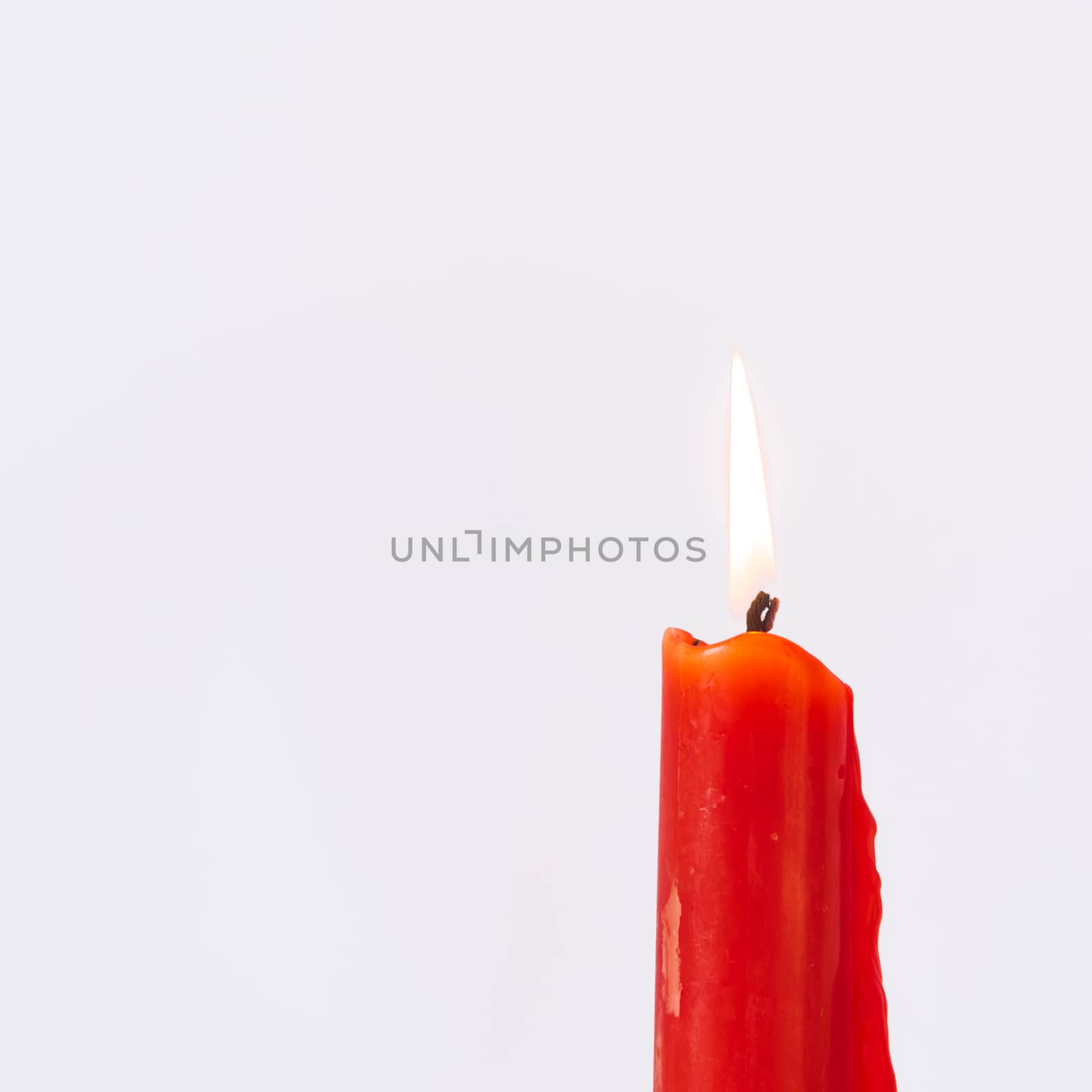 Studio shot one burning Asian red candle isolated on white by trongnguyen