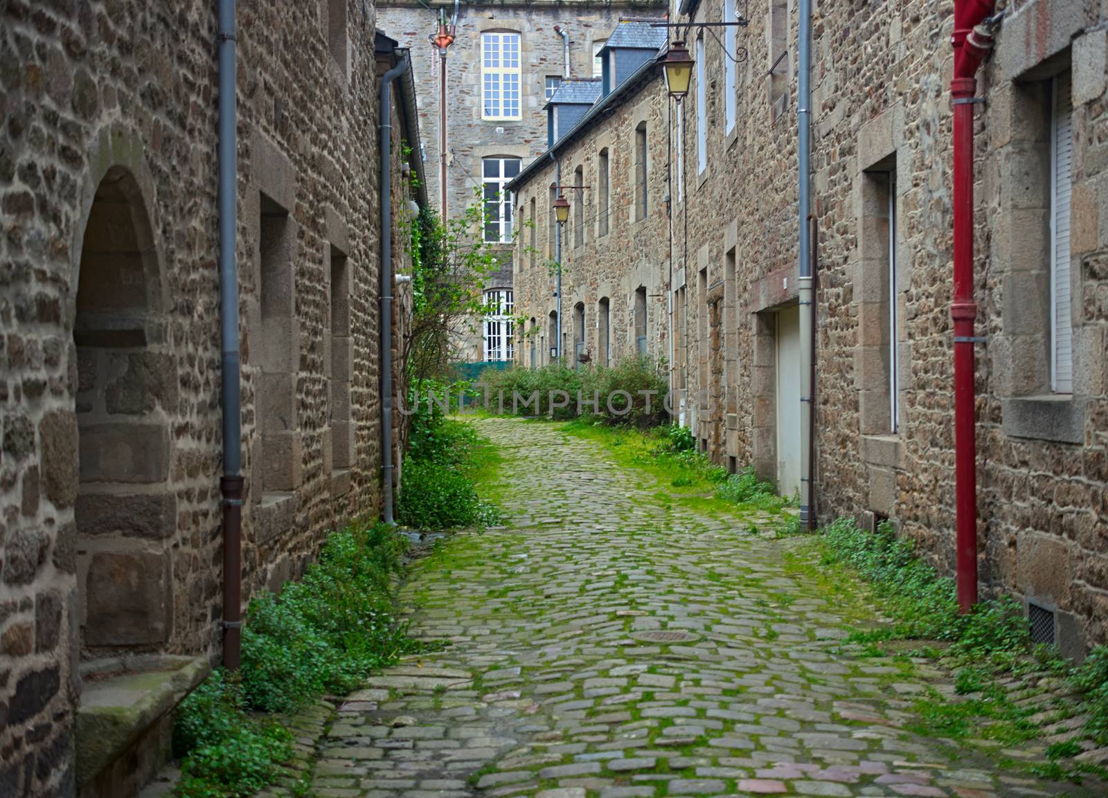 Old traditional narrow alley with houses made of stone in small french town by sheriffkule