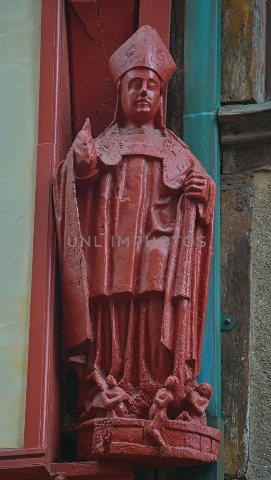 Vintage red wooden statue of an catholic priest by sheriffkule