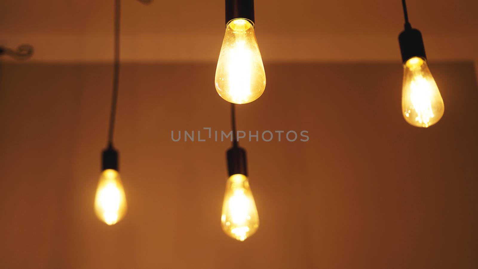 Decorative antique edison style light tungsten bulbs against yellow wall background