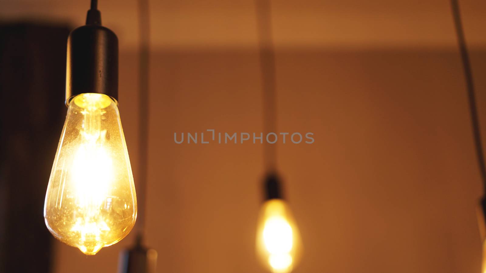 Decorative antique edison style light tungsten bulbs against yellow wall background