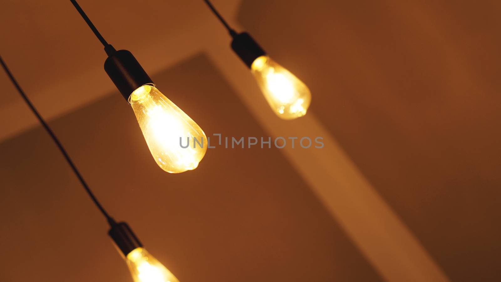 Decorative antique edison style light tungsten bulbs against yellow wall background
