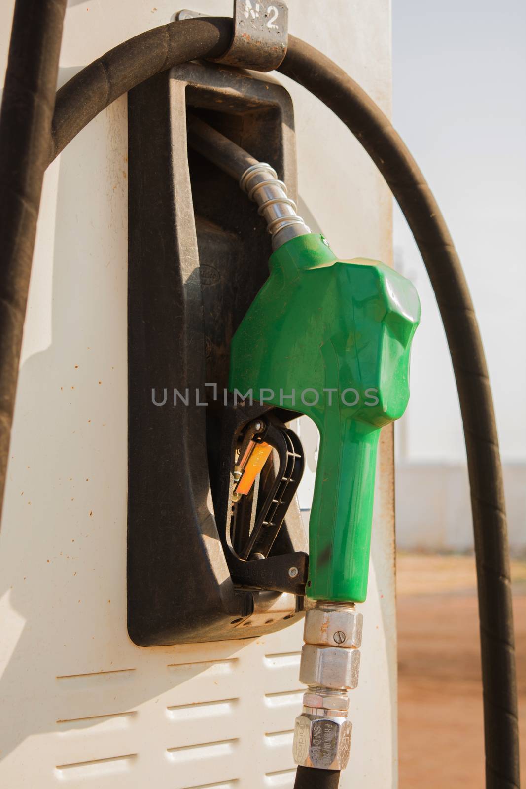 Fuel oil gasoline dispenser at petrol filling station.Holding fuel nozzle to refuel gasoline for car. by lakshmiprasad.maski@gmai.com