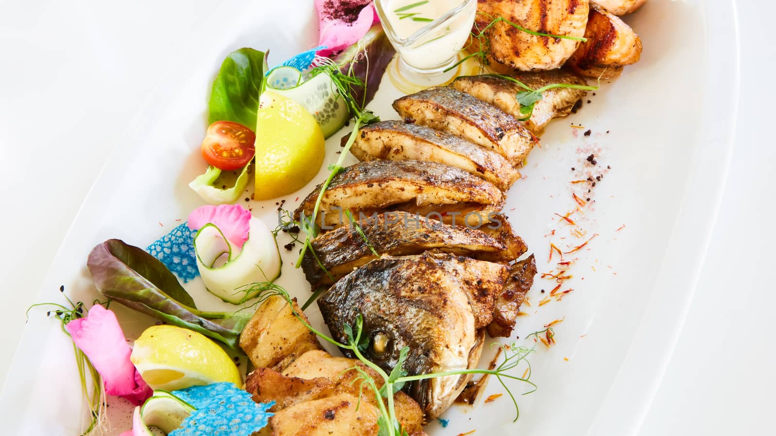 The fried fish on plate with vegetables. Shallow dof