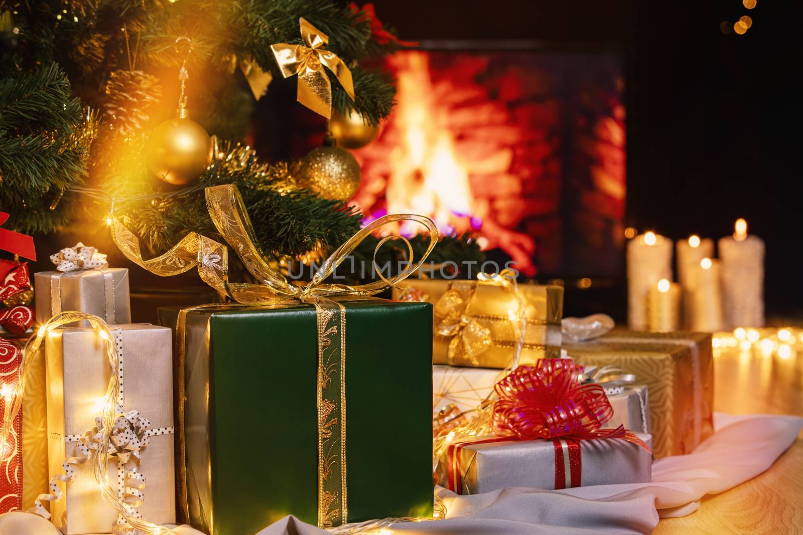 Christmas presents and candles under Christmas tree by manaemedia