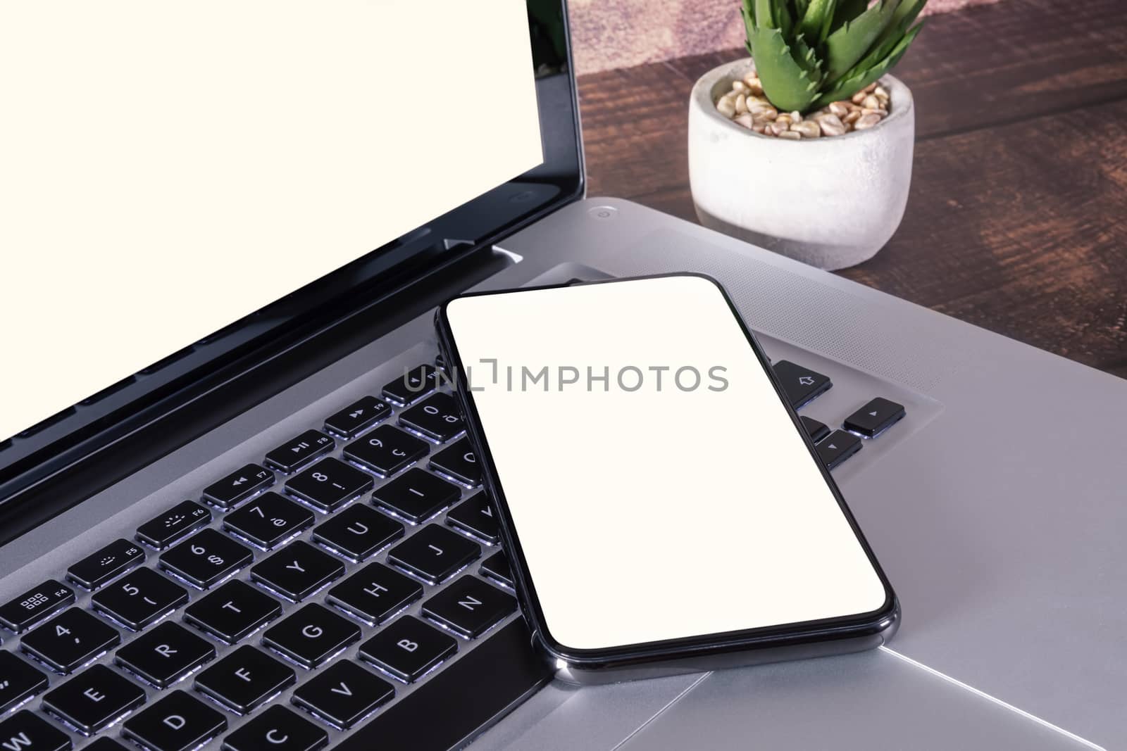 Smartphone white blank screen on laptop keyboard by manaemedia