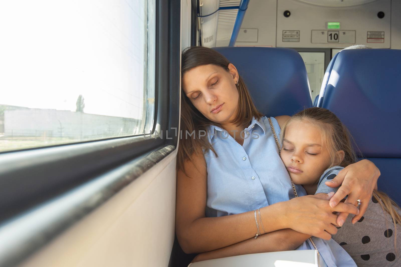 Mom and daughter hugging sleeping in a train car by Madhourse