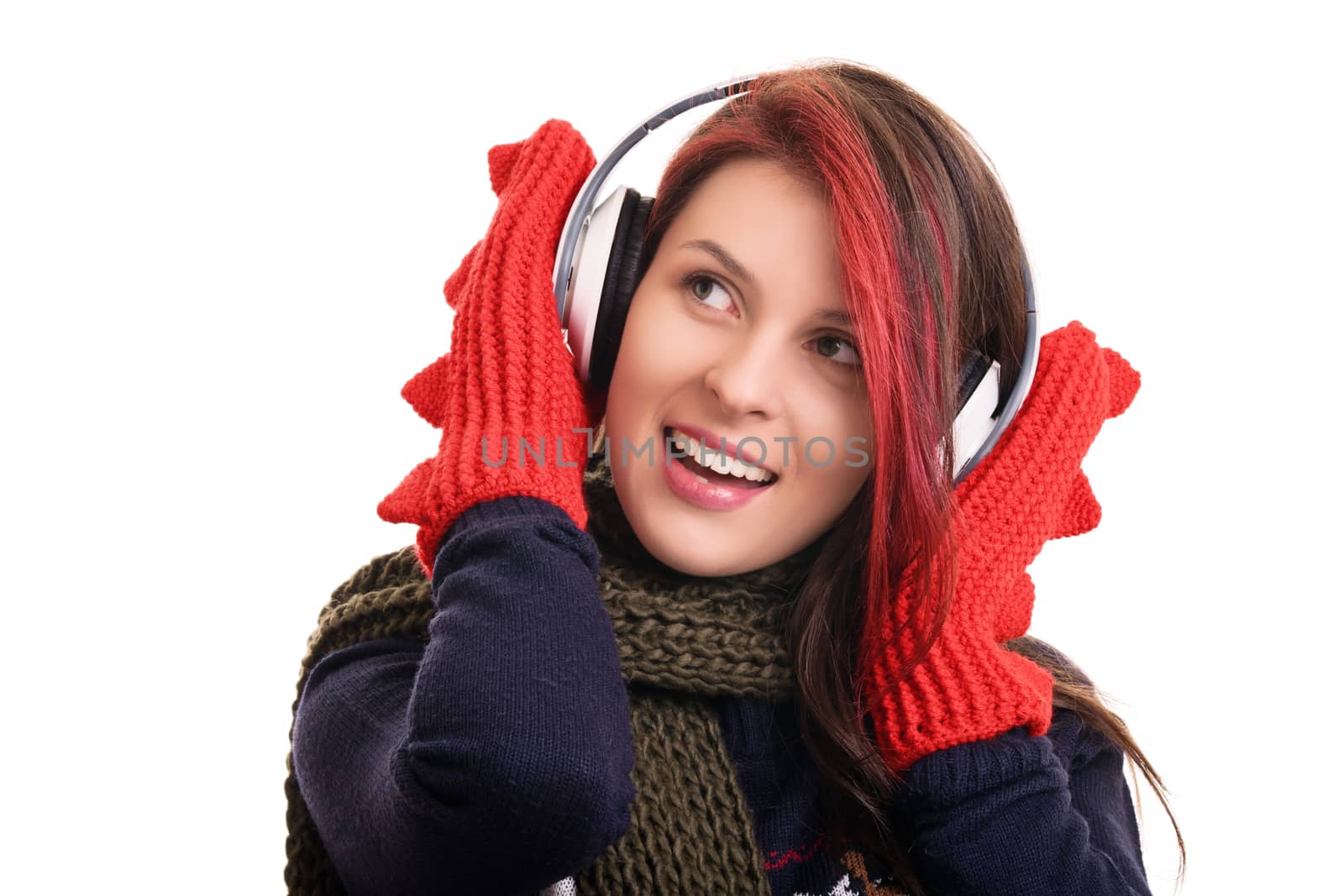 Portrait of a beautiful young girl with scarf and mittens listening to music on her headphones, isolated on white background.