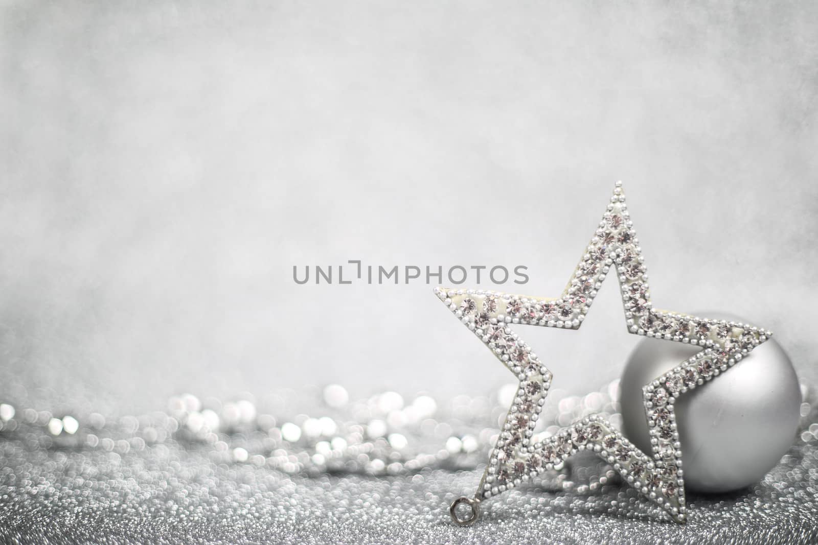 Christmas holiday composition of festive decor balls and star on silver glitter bokeh background