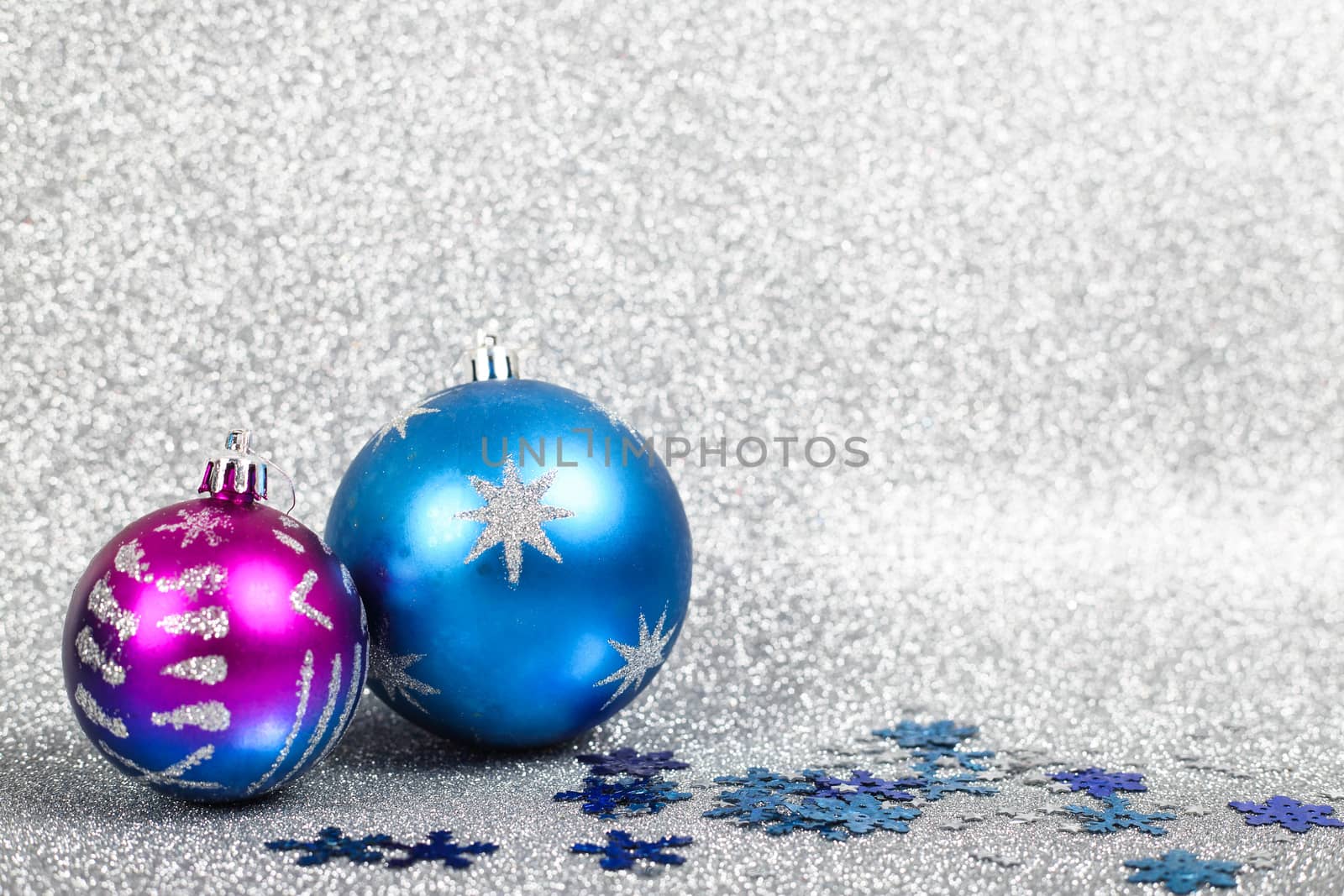 Christmas holiday composition of festive decor ball and snowflakes on silver glitter bokeh background