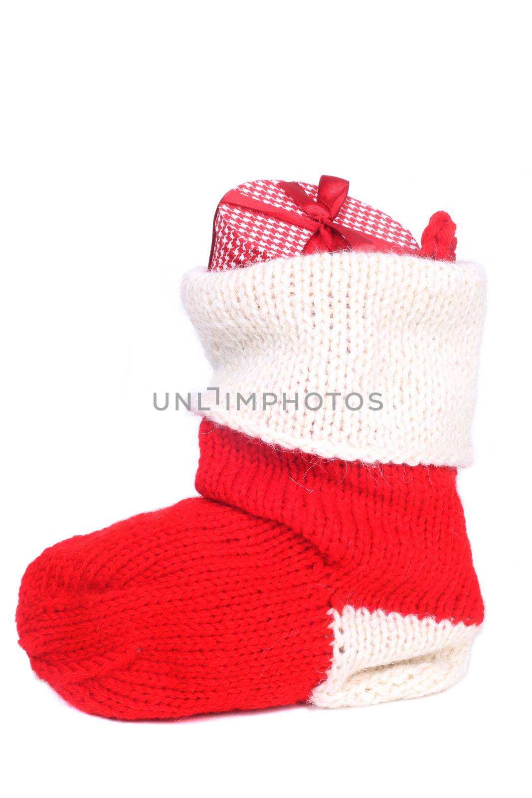 Stuffed Christmas stocking red and white woolen sock with gifts inside isolated on white background