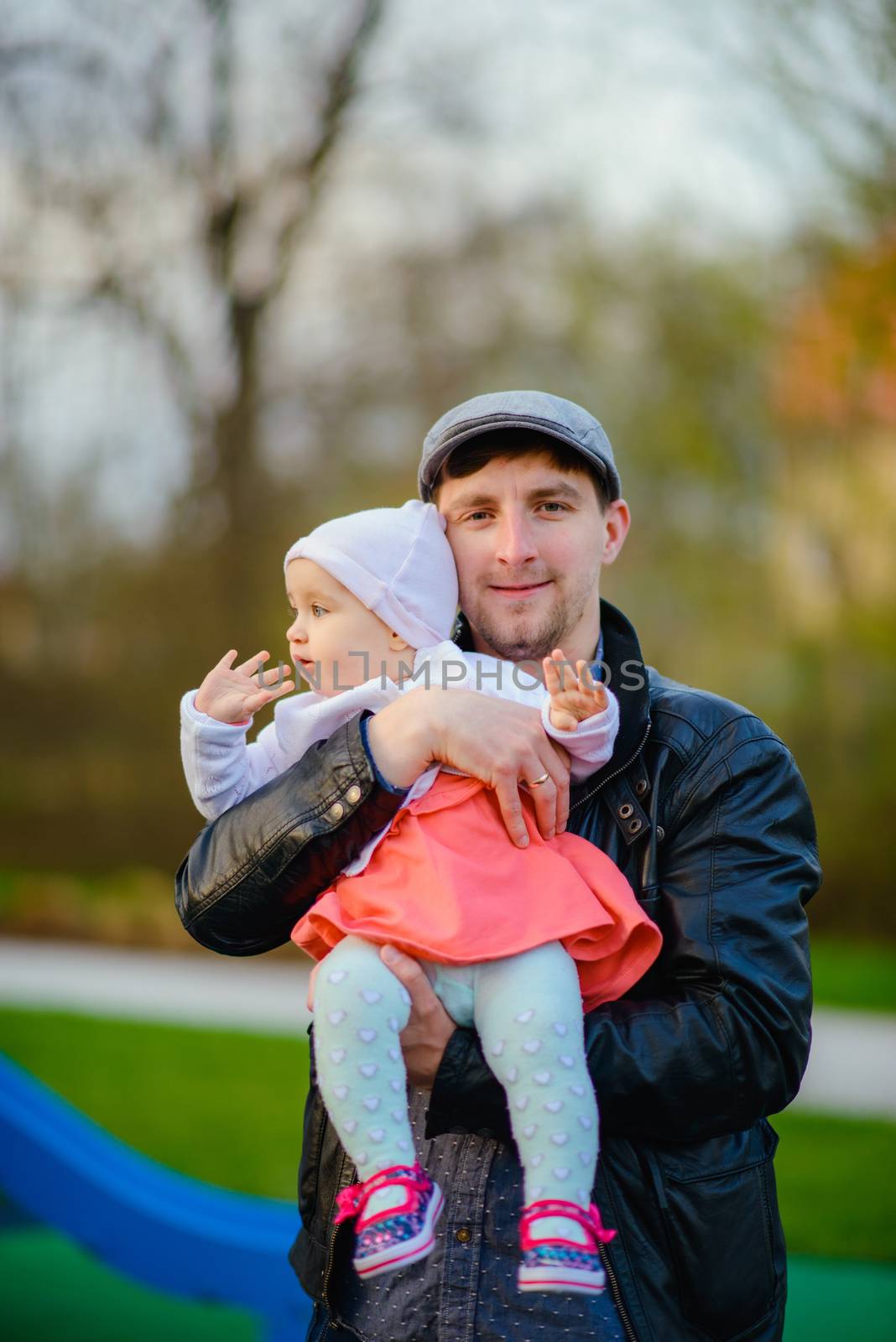 Happy loving family. Father and his daughter child girl playing and hugging outdoors. Cute little girl hugs daddy. Concept of Father's day. Authentic image.