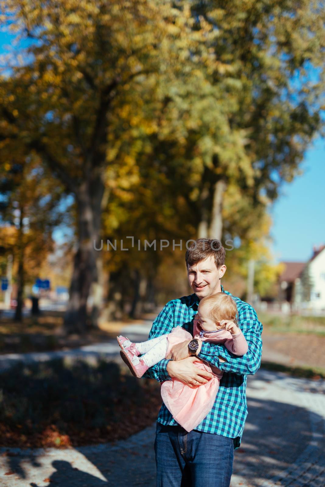 Happy loving family. Father and his daughter child girl playing and hugging outdoors. Cute little girl hugs daddy. Concept of Father's day. Authentic image.