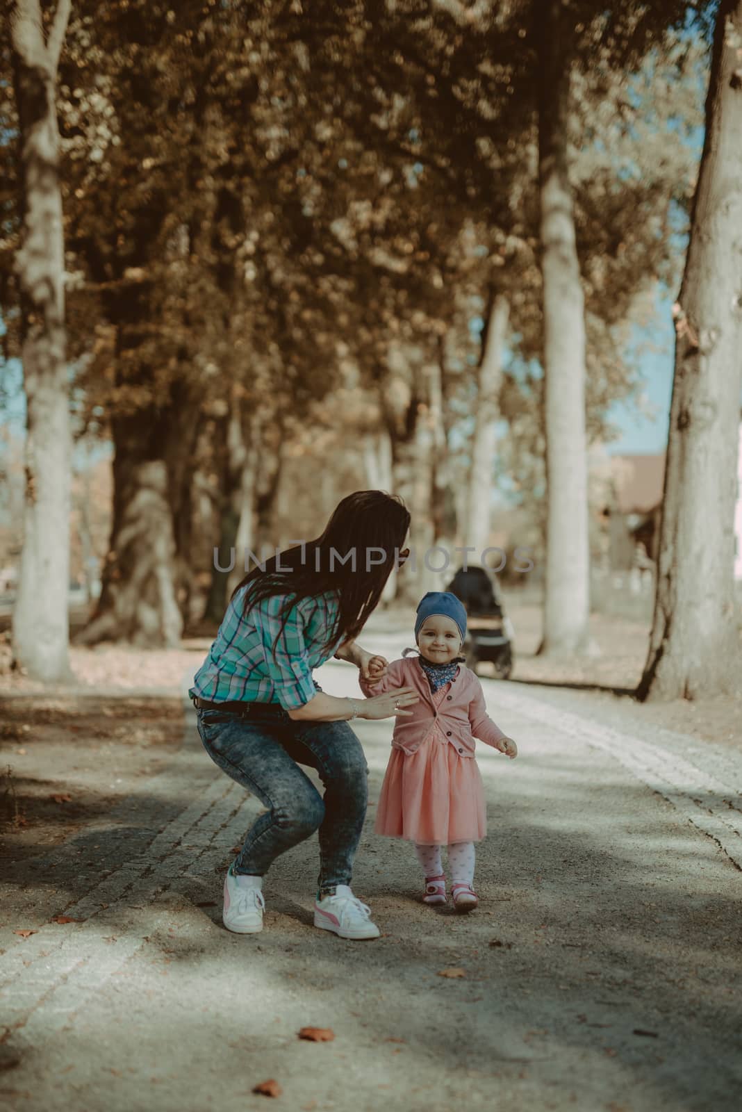 Happy mother and daughter in the park. Beauty nature scene with  by Brejeq