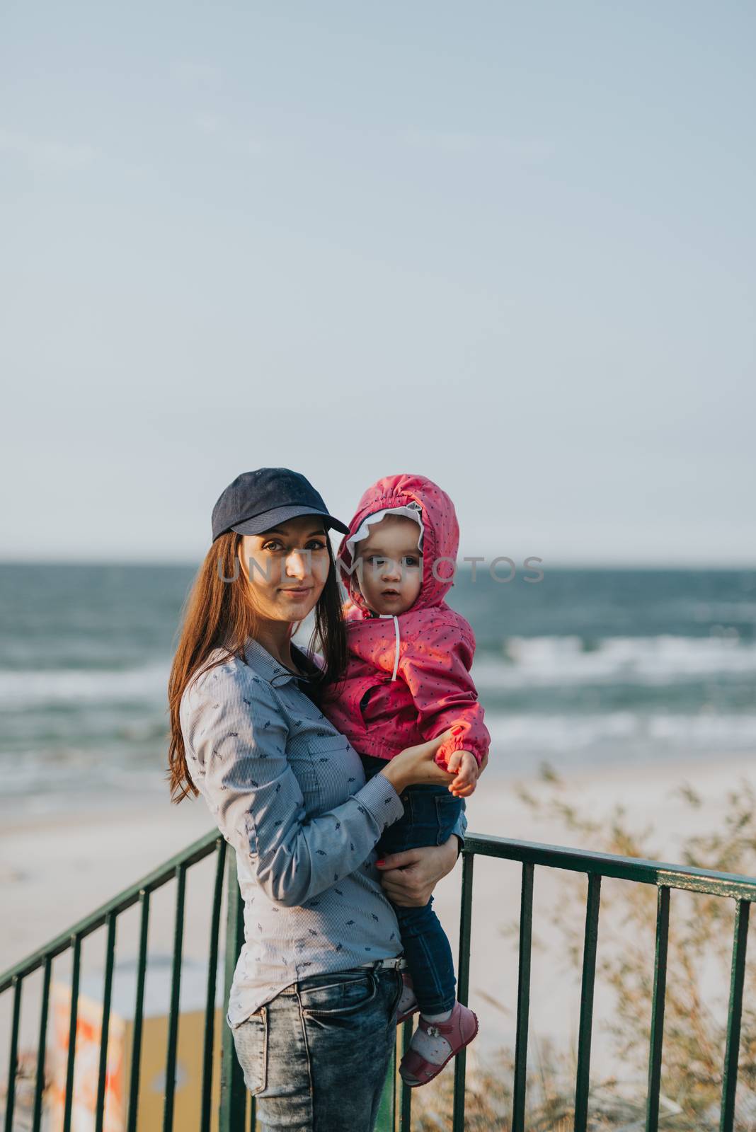 Mother and little daughter playing on the beach. Authentic image.