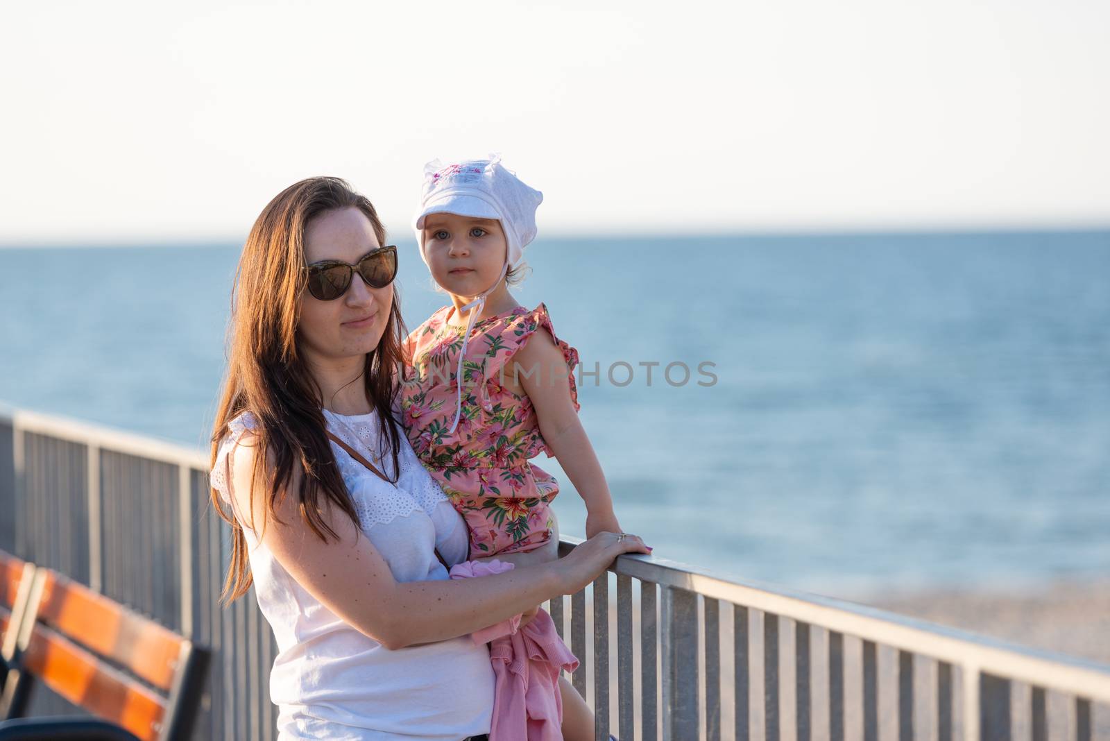 Mother and little daughter playing on the beach. Authentic image.