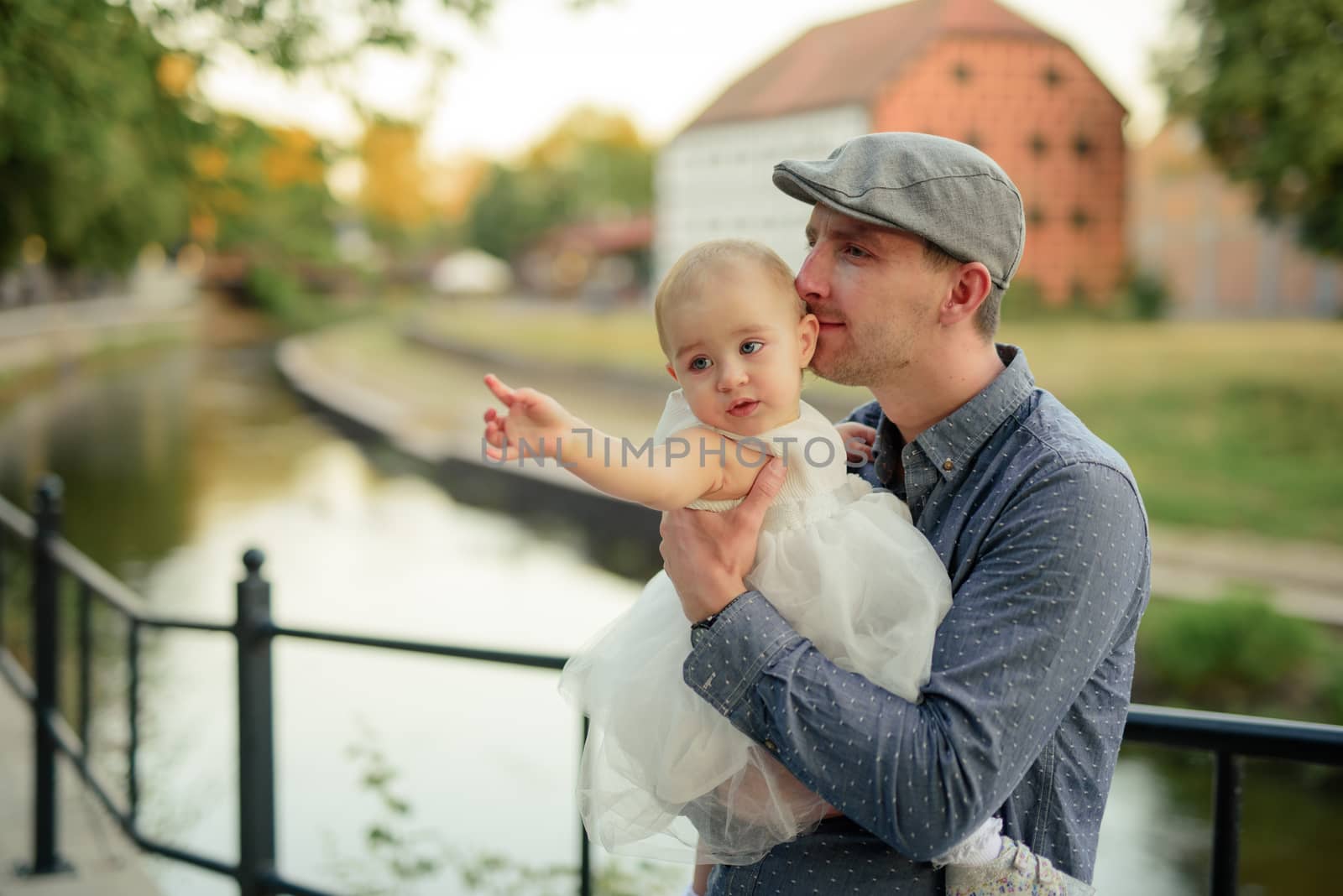 Happy loving family. Father and his daughter child girl playing and hugging outdoors. Cute little girl hugs daddy. Concept of Father's day. Authentic image.