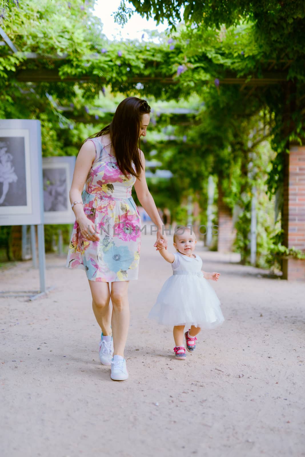 Happy mother and daughter in the park. Beauty nature scene with  by Brejeq