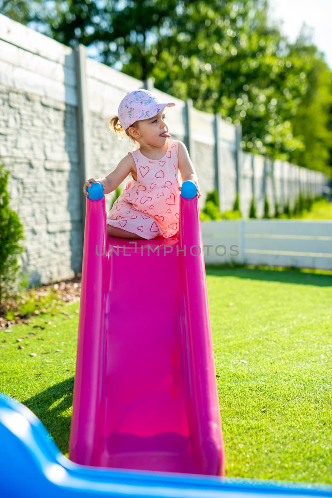 Little girl spending fantastic time on playground. Happy childhood. Authentic image