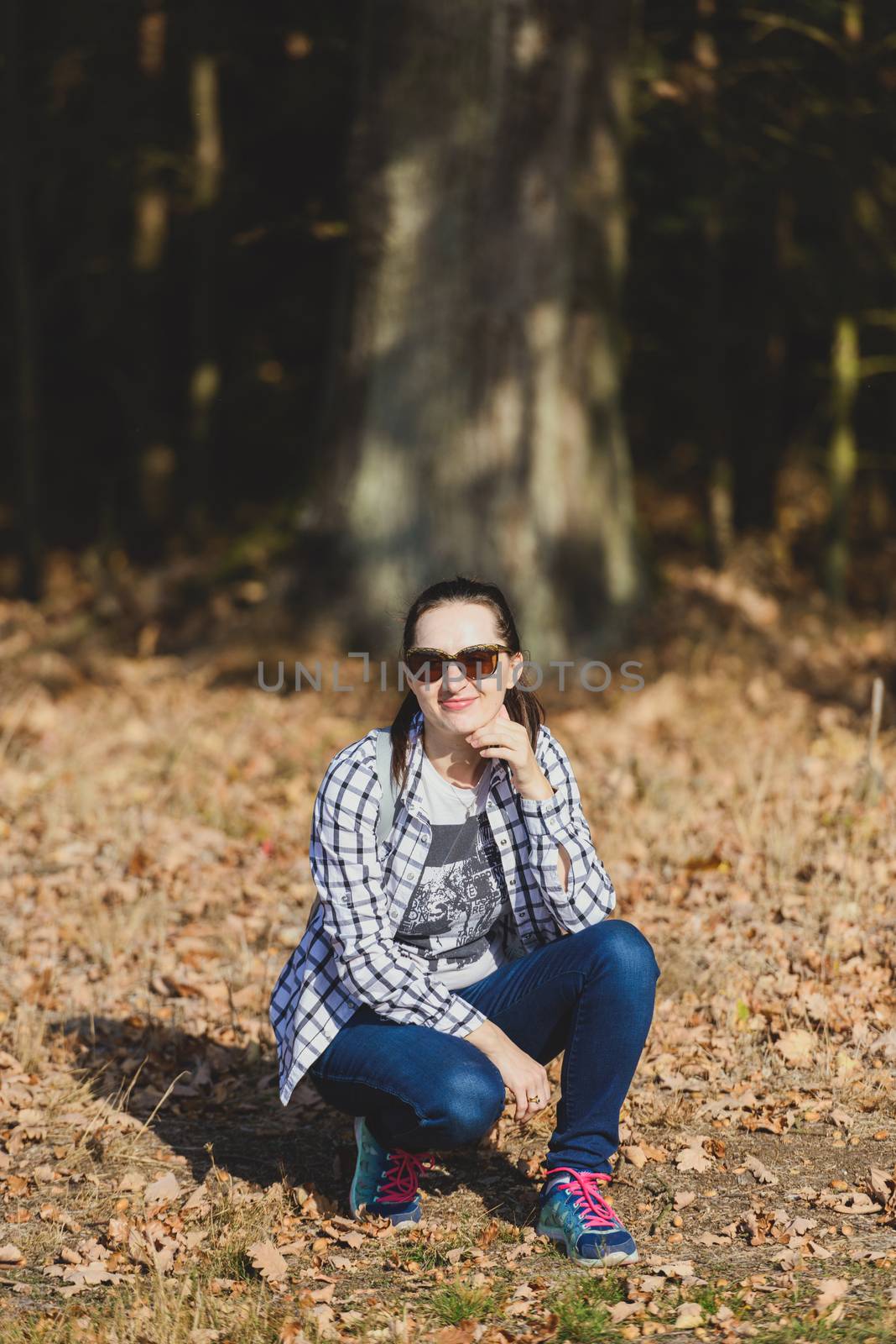 Autumn attractive woman portrait smiling outdoors at the park. A by Brejeq