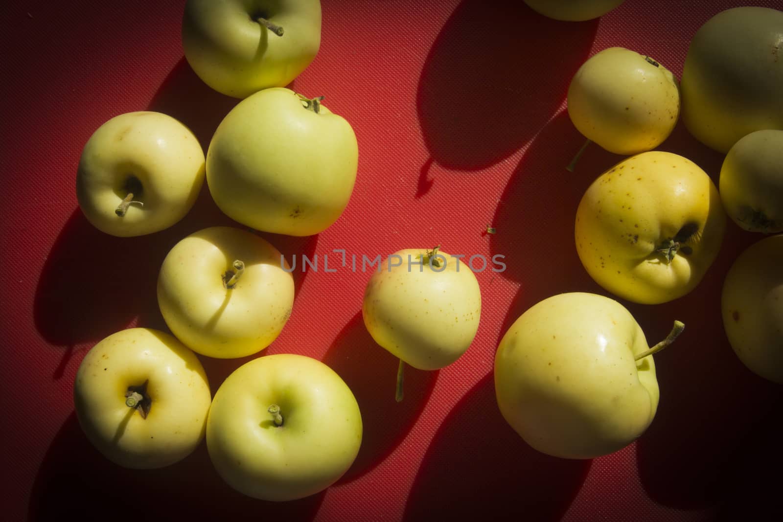 Yellow apples on a table with a red tablecloth