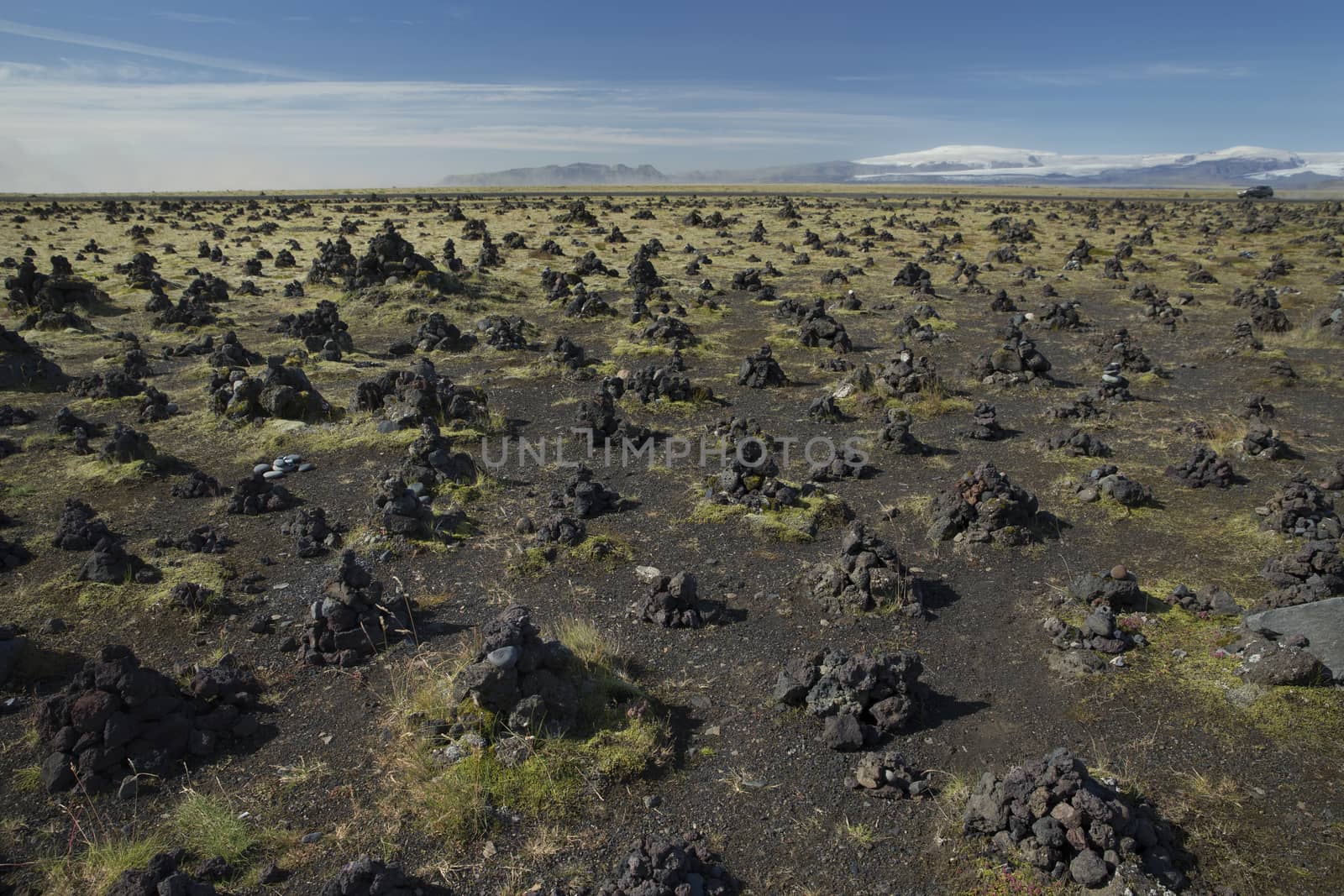 Icelandic Landscape with piles of stones and Mountains on background