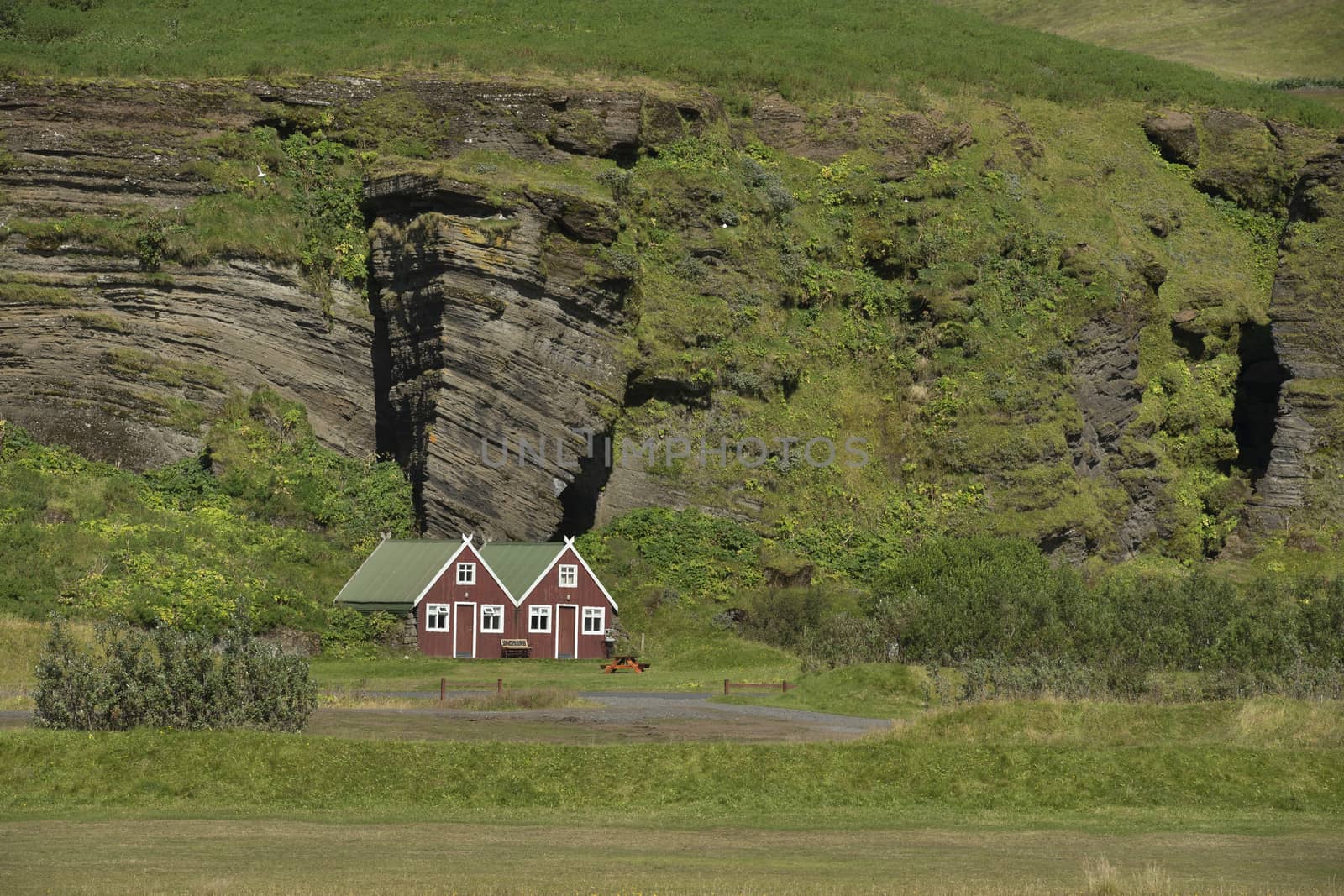 Landscape with Traditional iclandic wooden houses for turists on rock at the bottom of mountain.