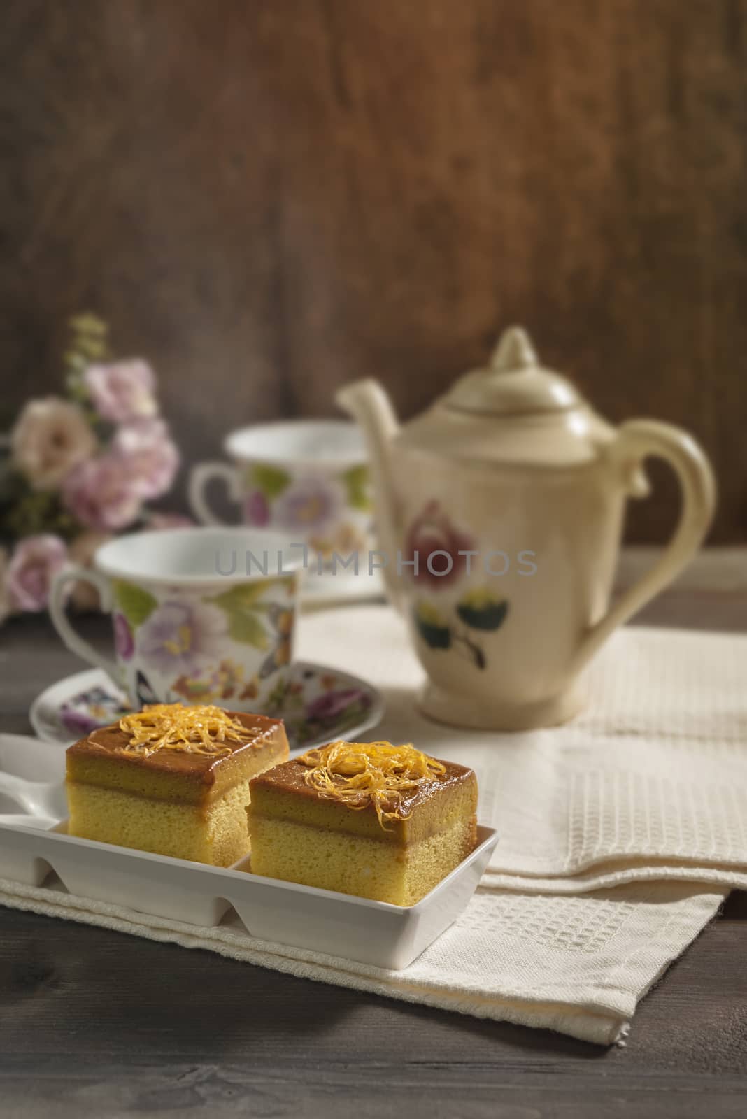 hot tea and sweet cake over wooden table