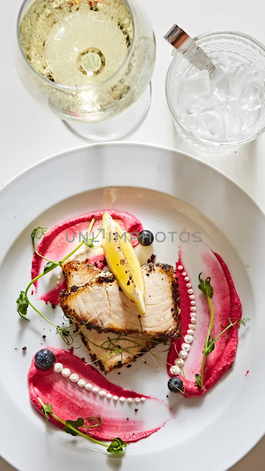White fish with lemon on white plate, selective focus.