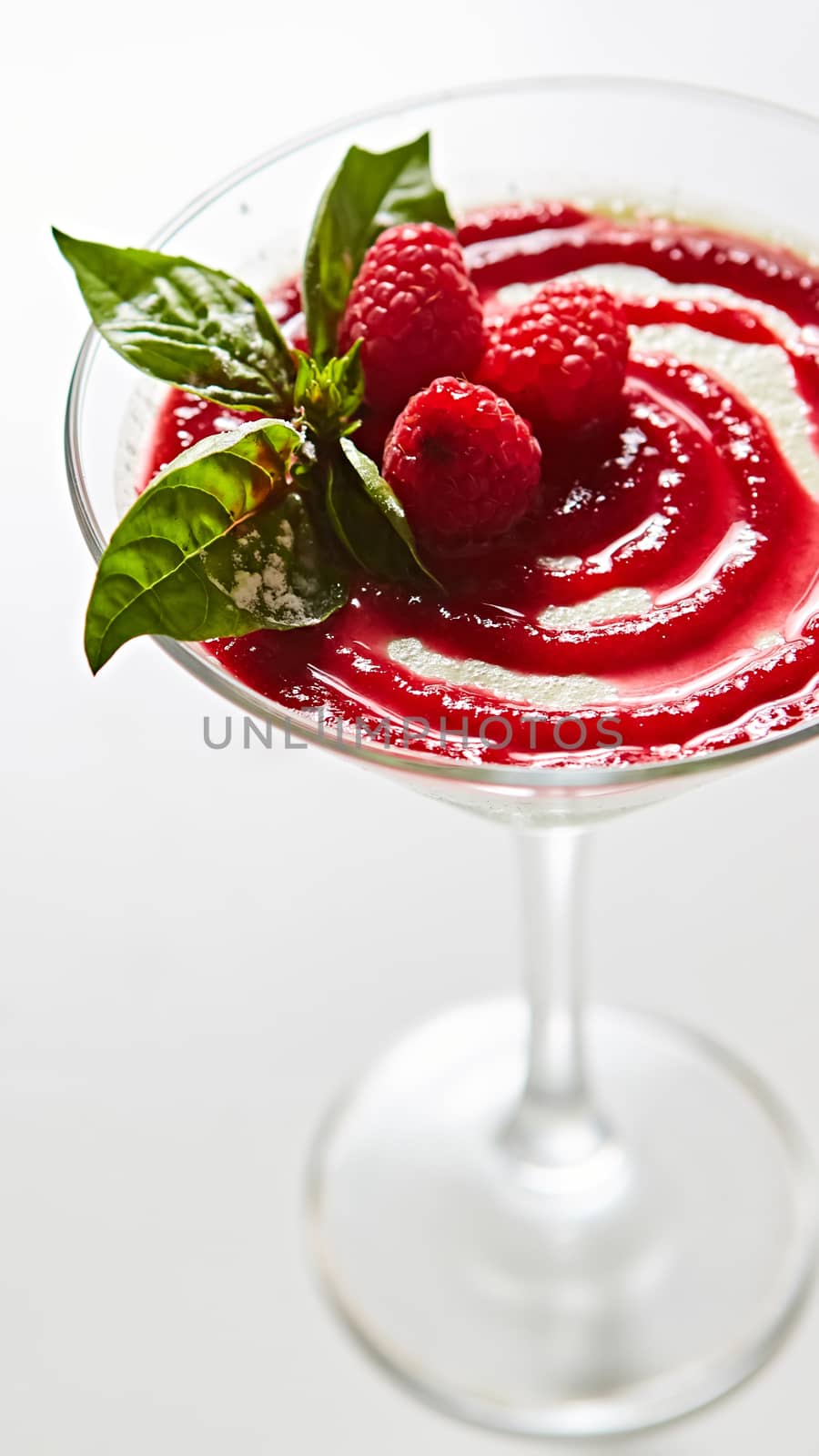 Delicious Italian dessert Panna Cotta with raspberry in small transparent glass by sarymsakov