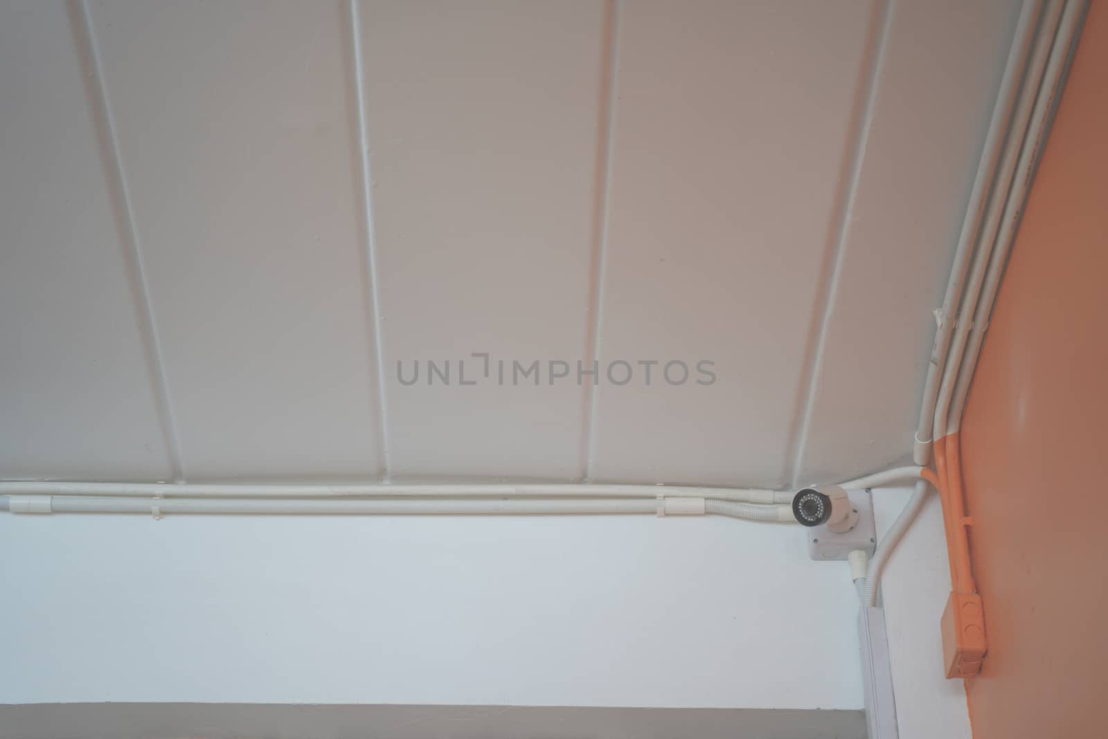 A CCTV security camera installed on ceiling building