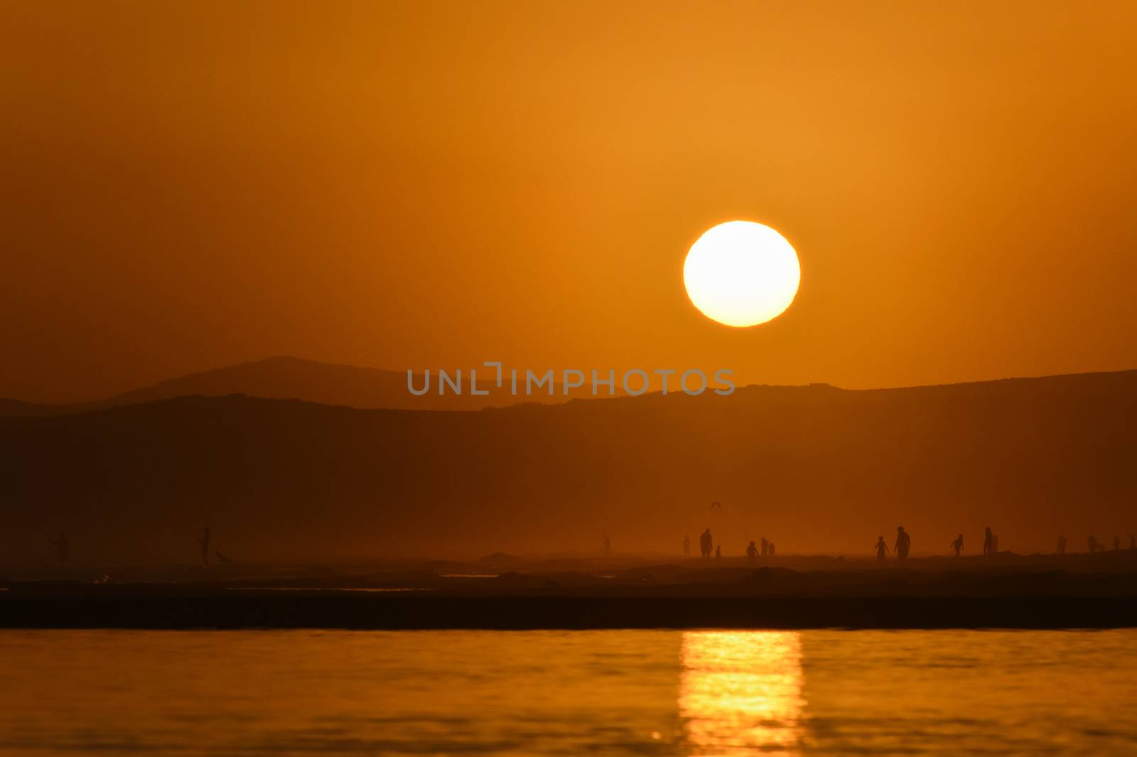 Sunset on an African south coast beach with the sun reflecting over tide pool, Mossel Bay, South Africa