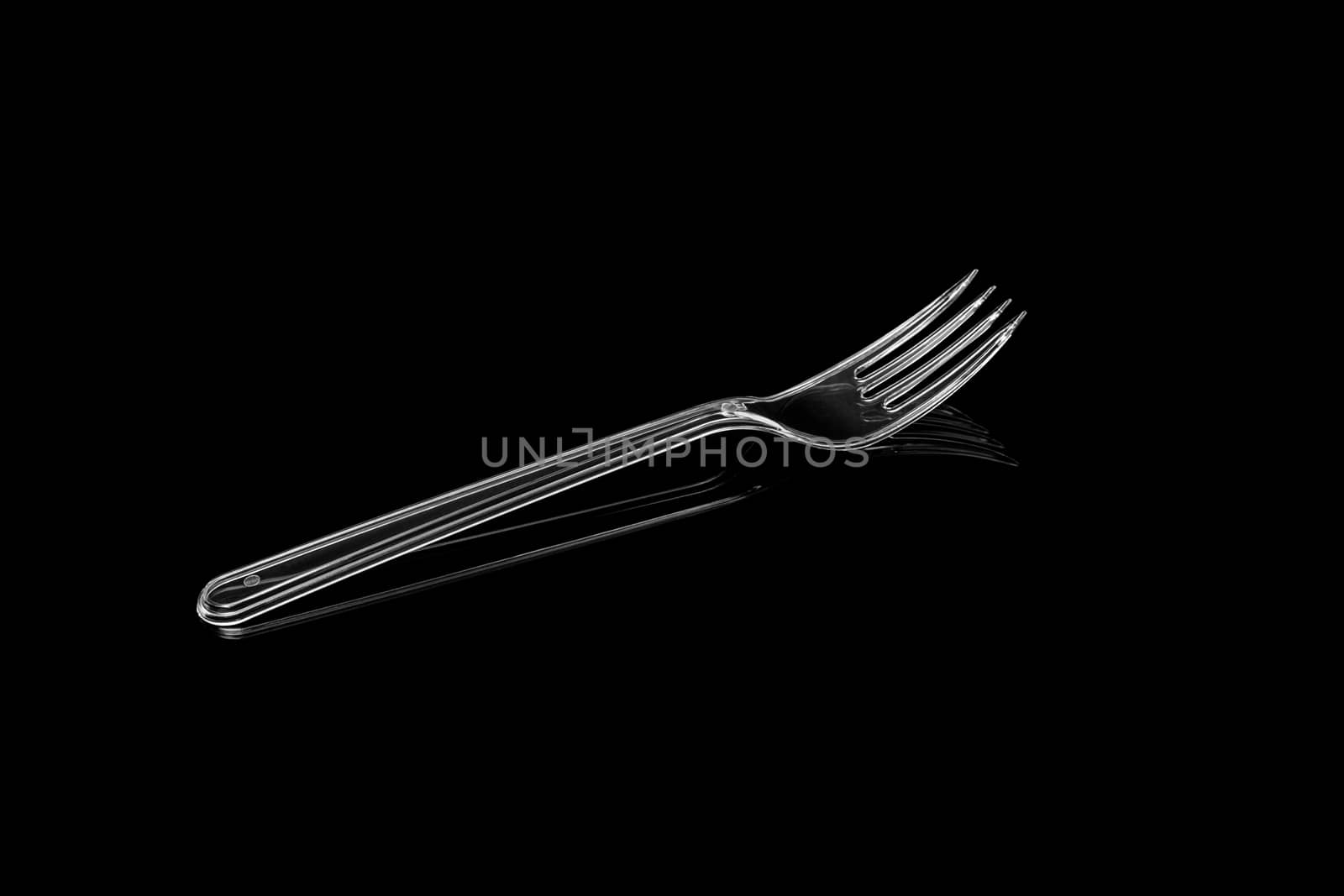 Transparent plastic fork isolated on black background. With clipping path