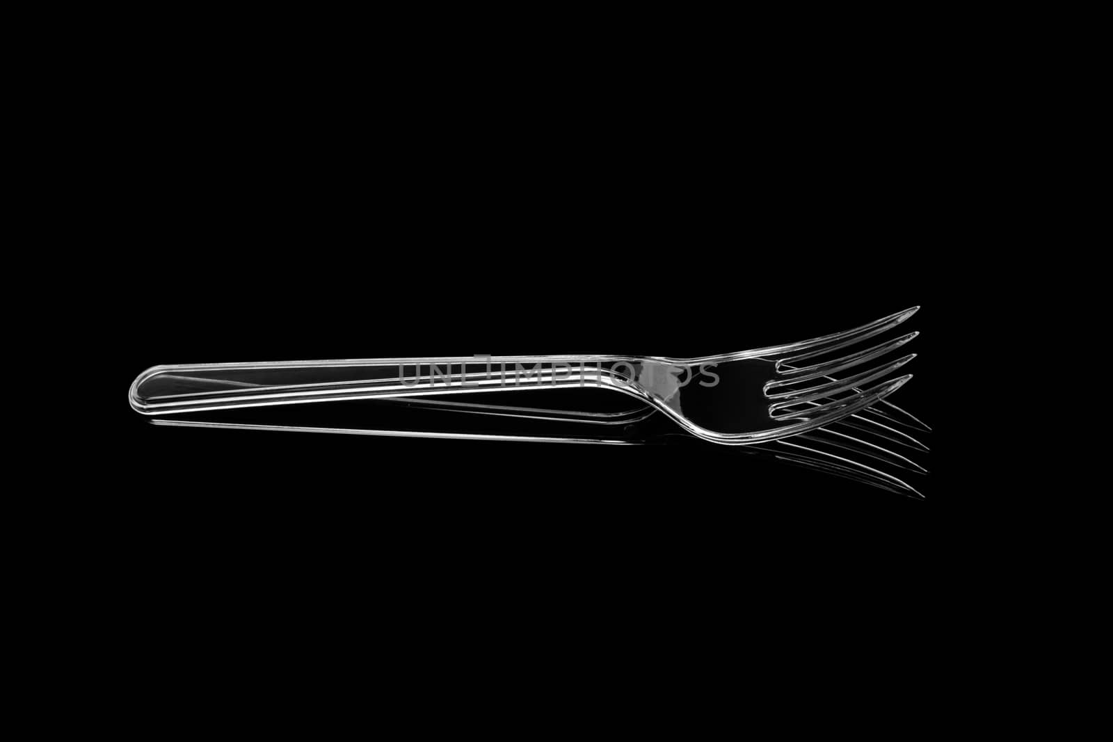 Transparent plastic fork isolated on black background. With clipping path