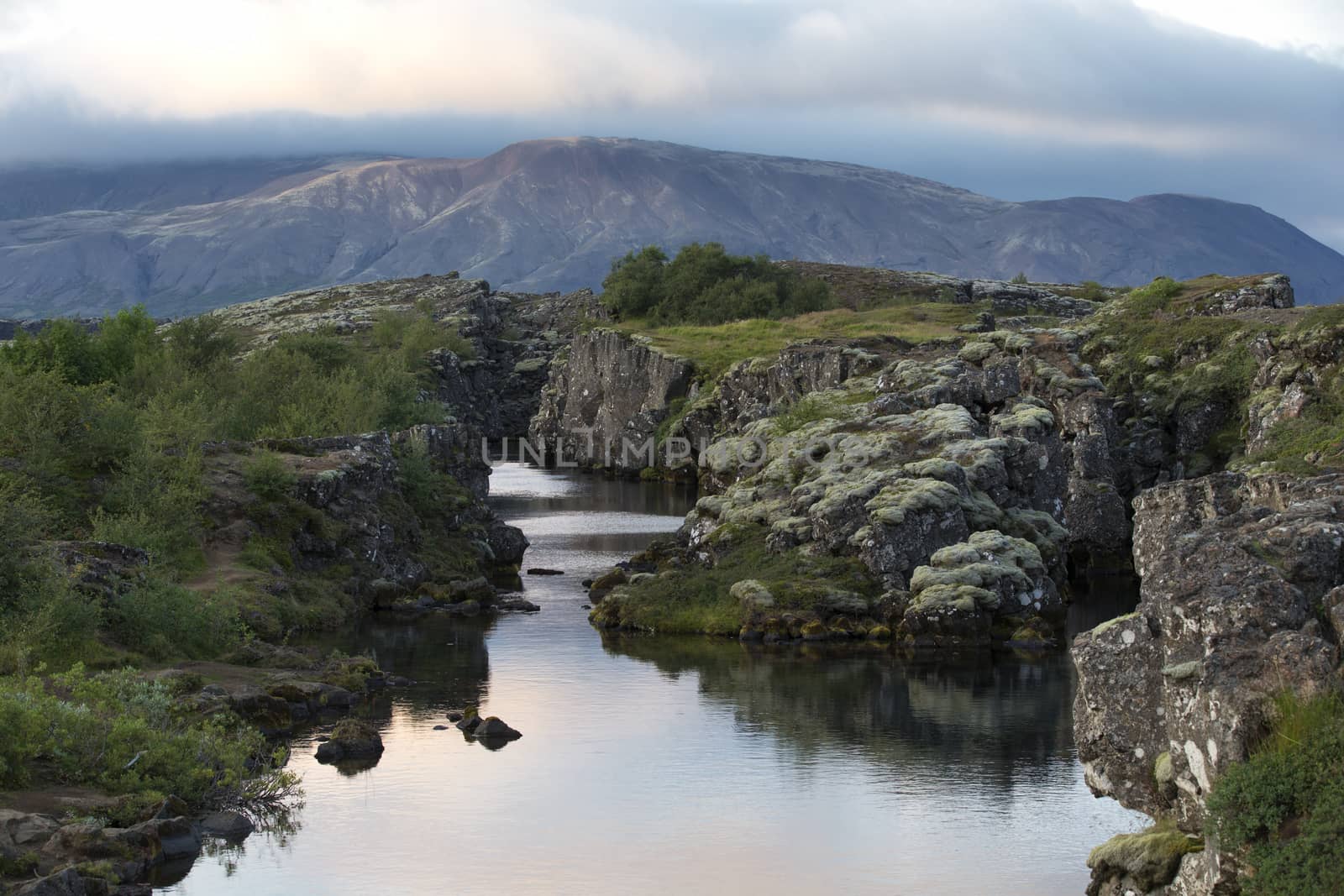 Typical icelandic landscape with volcanoes, mountains and river at sunset.