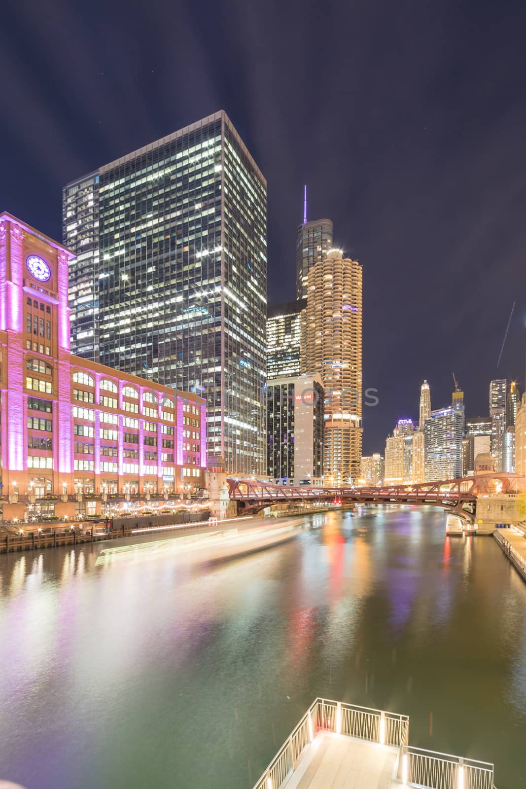 Boat tour light trail and Chicago skylines at blue hour with marina cove patio by trongnguyen
